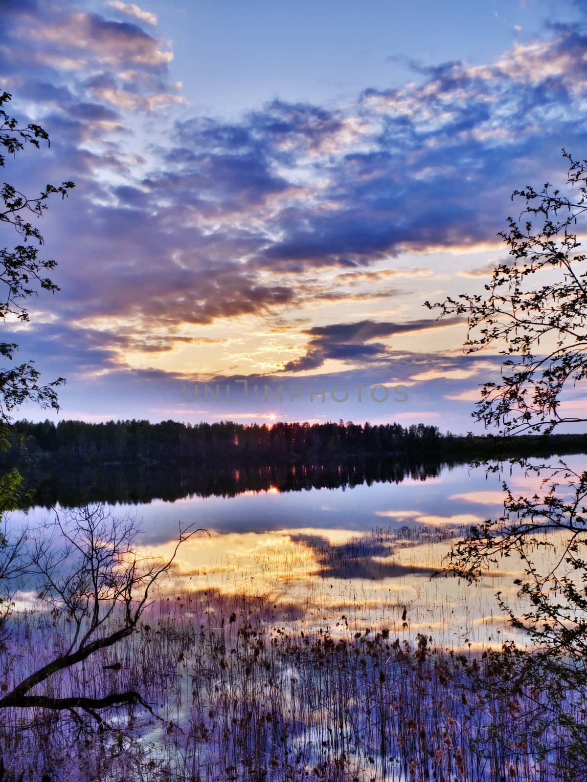 Blue cloudy sunset on spring lake