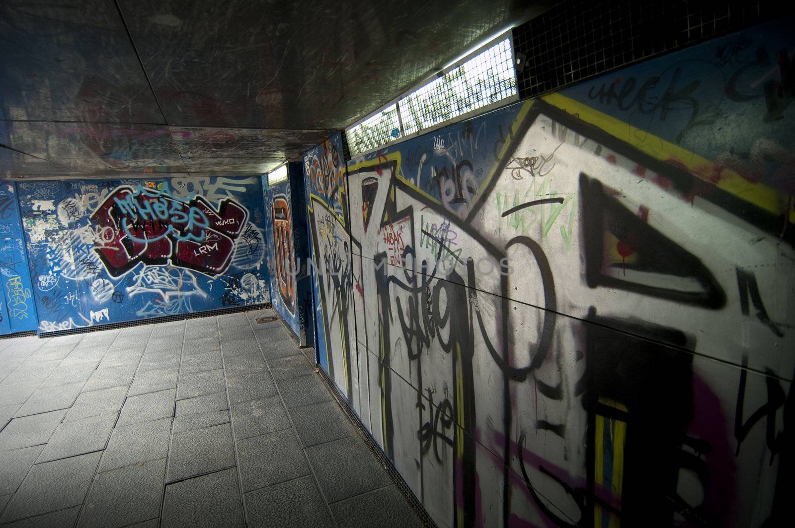 A tunnel with many graffiti painted on walls