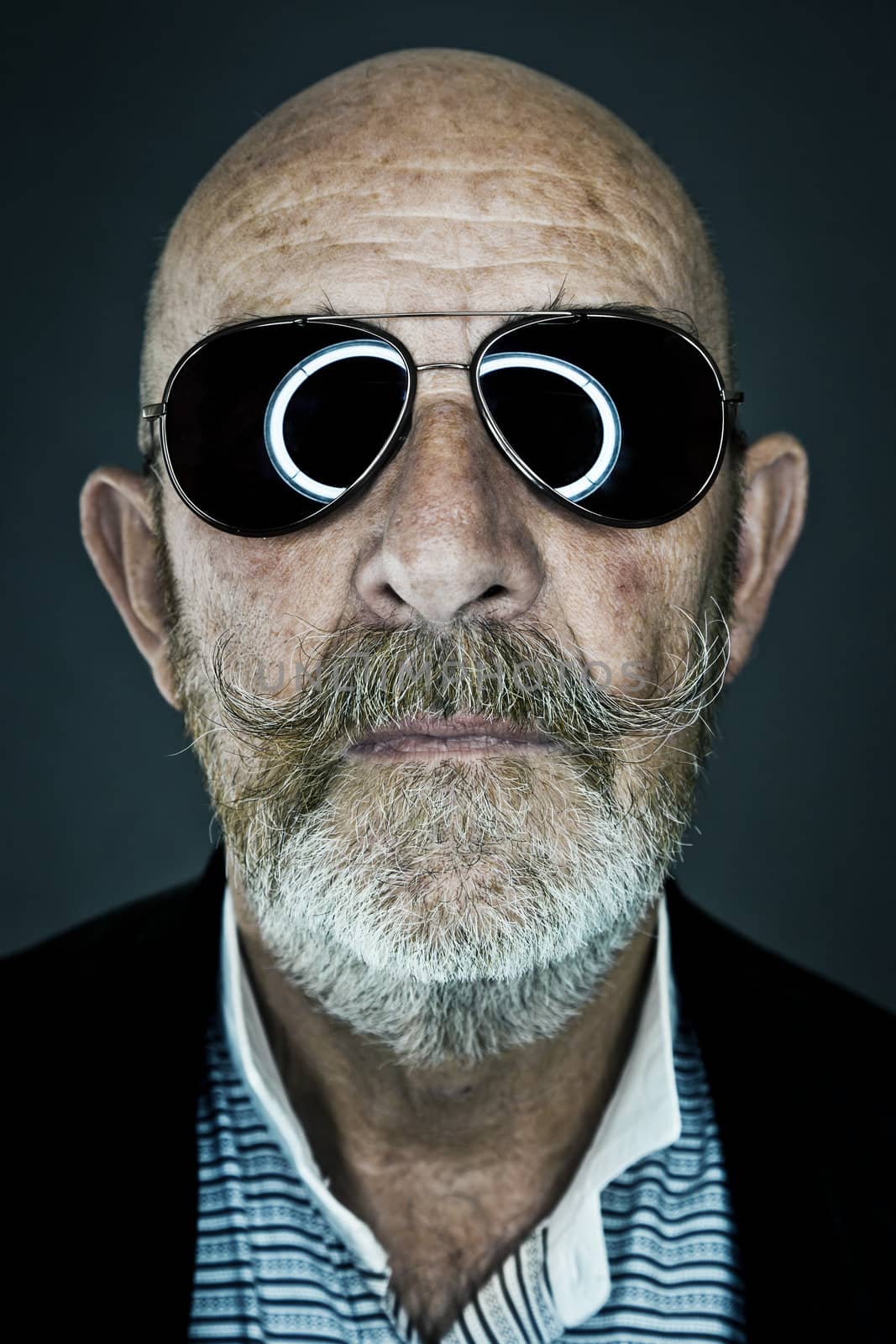 An old man with a grey beard wearing sunglasses