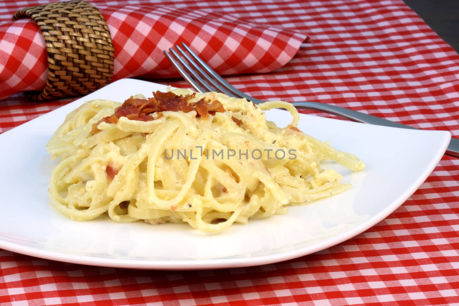 Gourmet exquisite carbonara pasta plate made with fancy organic bacon, eggs, heavy cream, and  parmesan cheese  