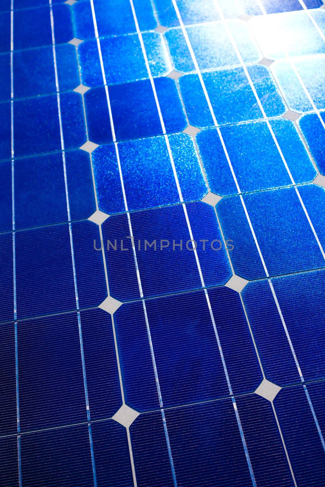 Pattern of solar cell wafers in photovoltaic solar panel with sun glare.