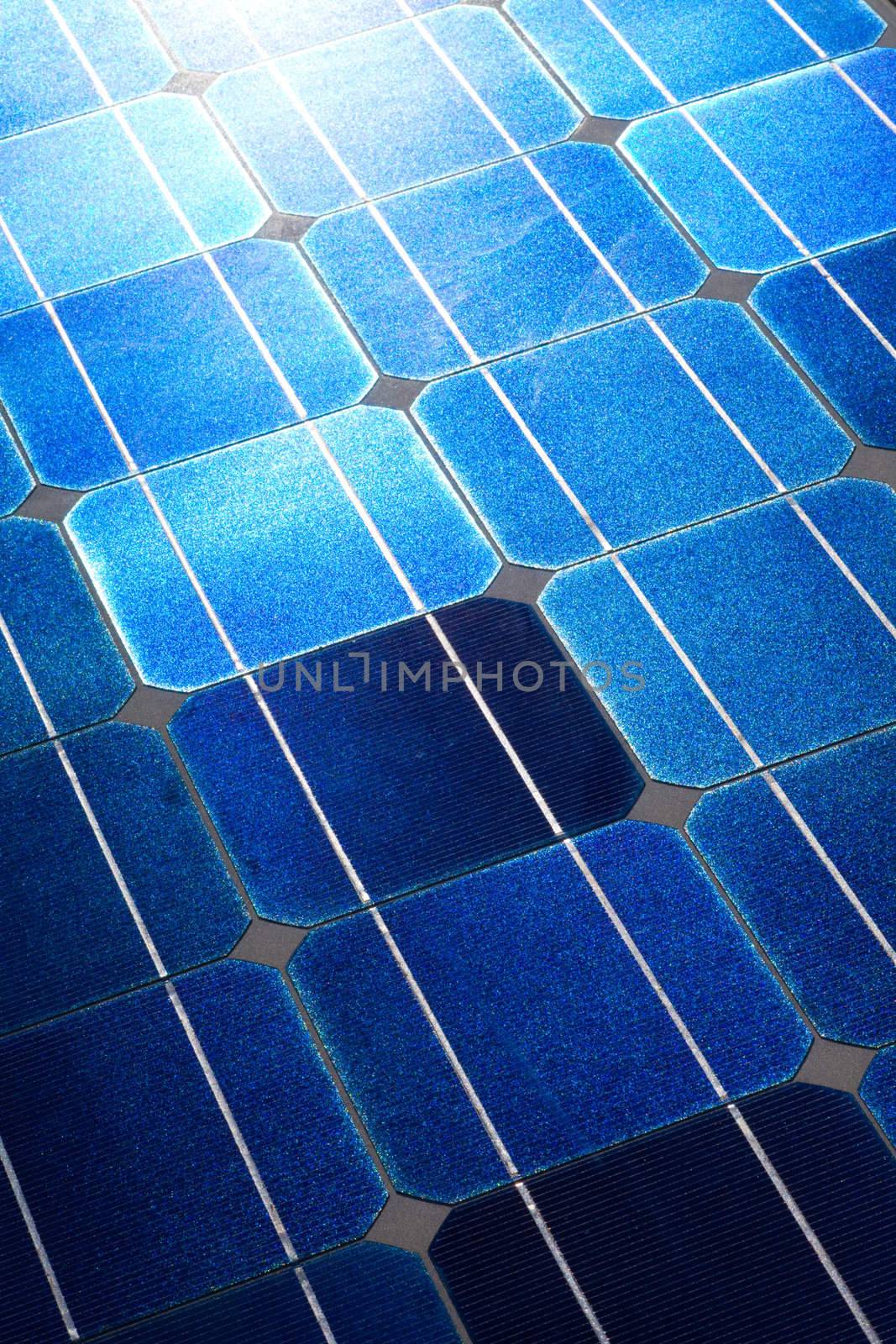 Pattern of solar cell wafers in photovoltaic solar panel with sun glare.