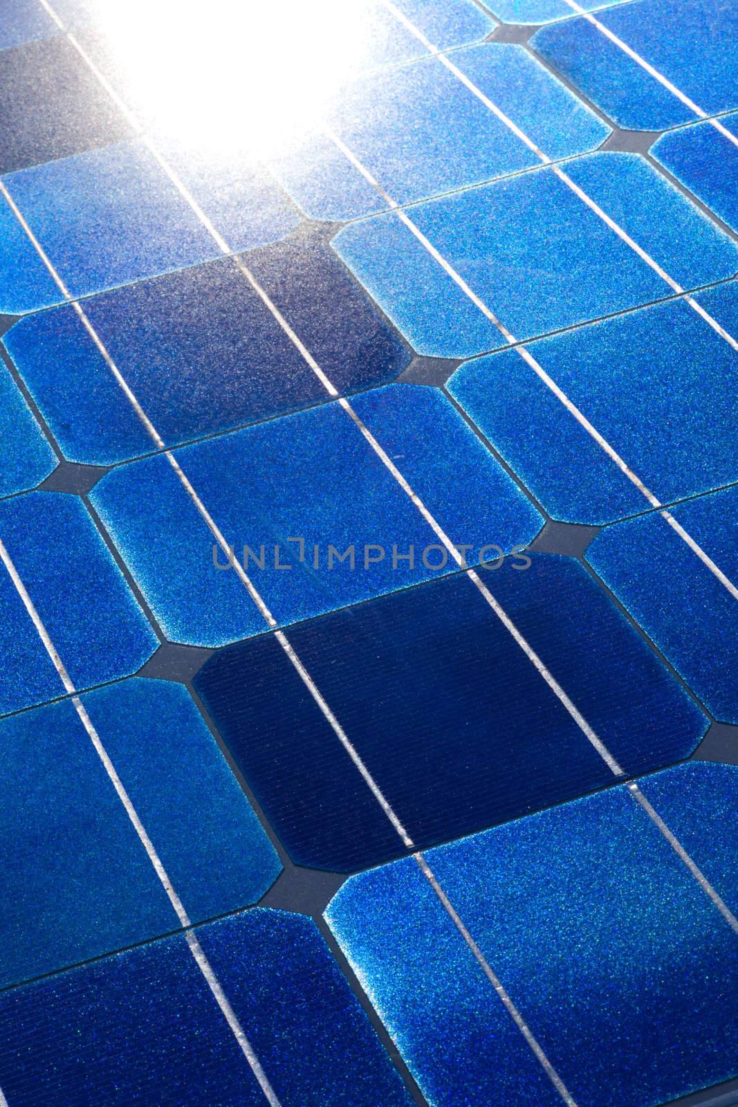 Pattern of solar cell wafers in photovoltaic solar panel with sun glare.