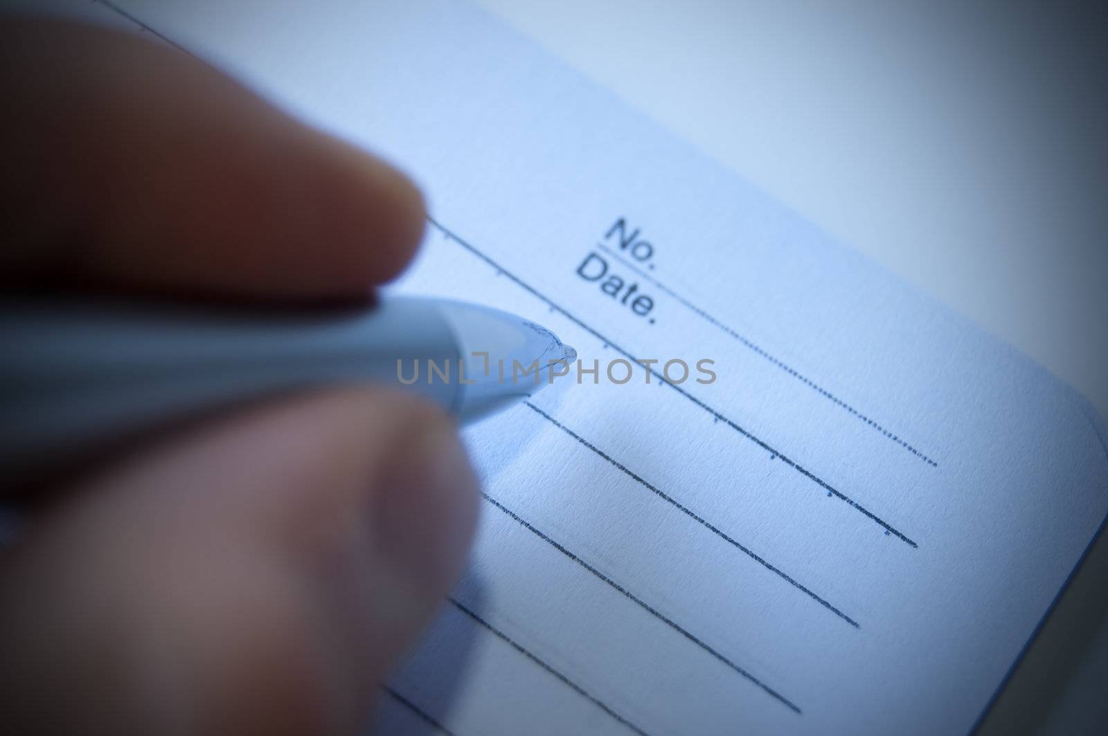 Writing with an elegant silver pen on a book