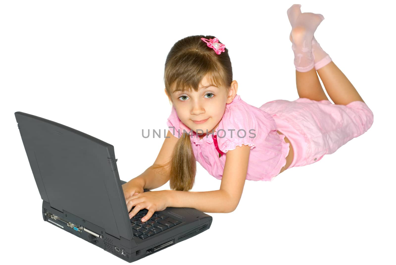 The girl in pink clothes lays near a notebook computer