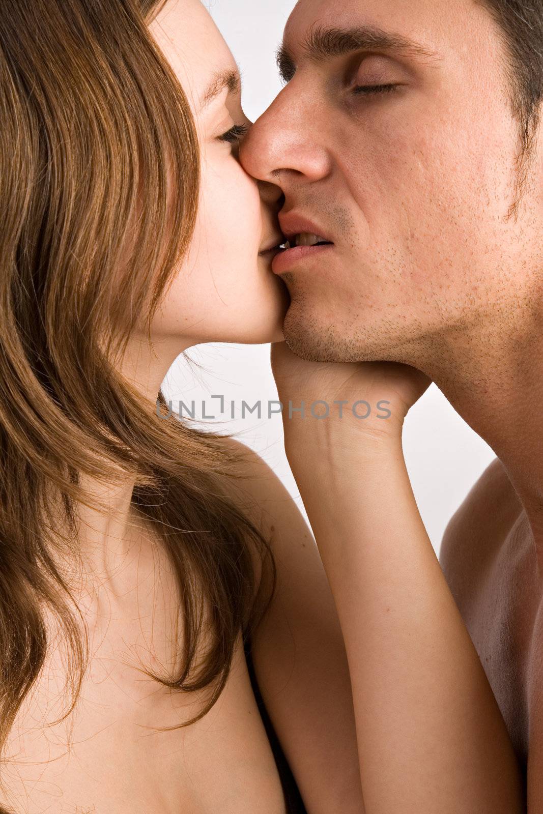 Young adult couple in the studio kissing