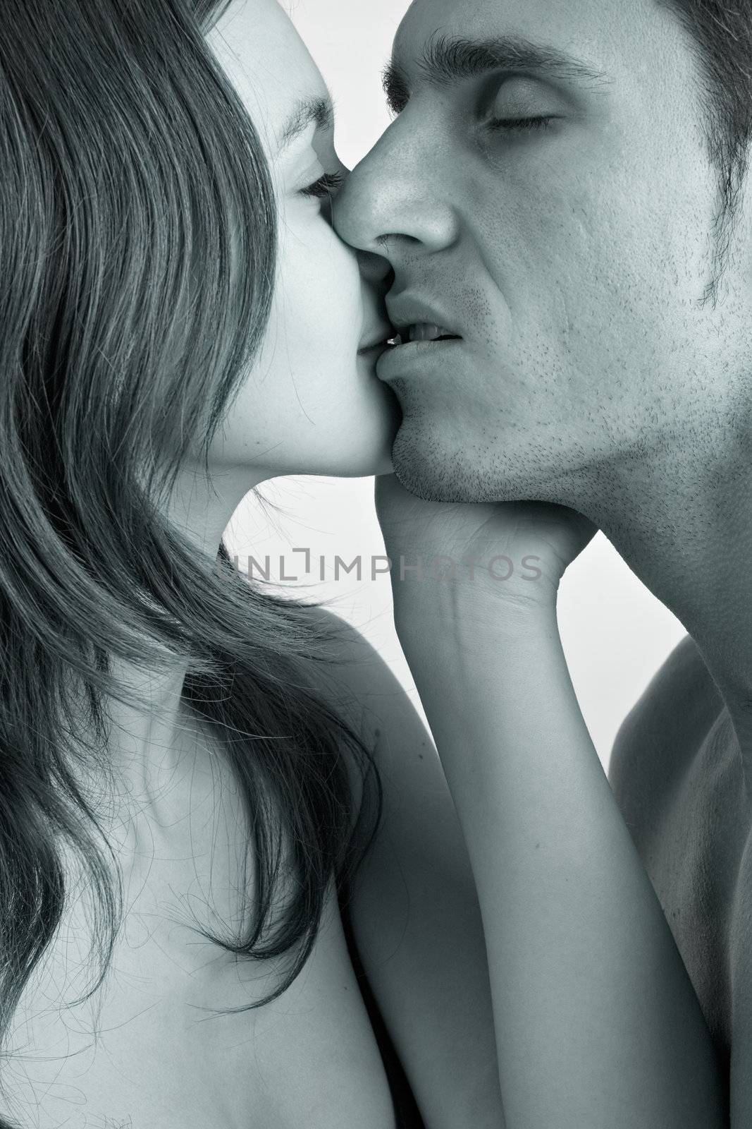 Young adult couple in the studio kissing