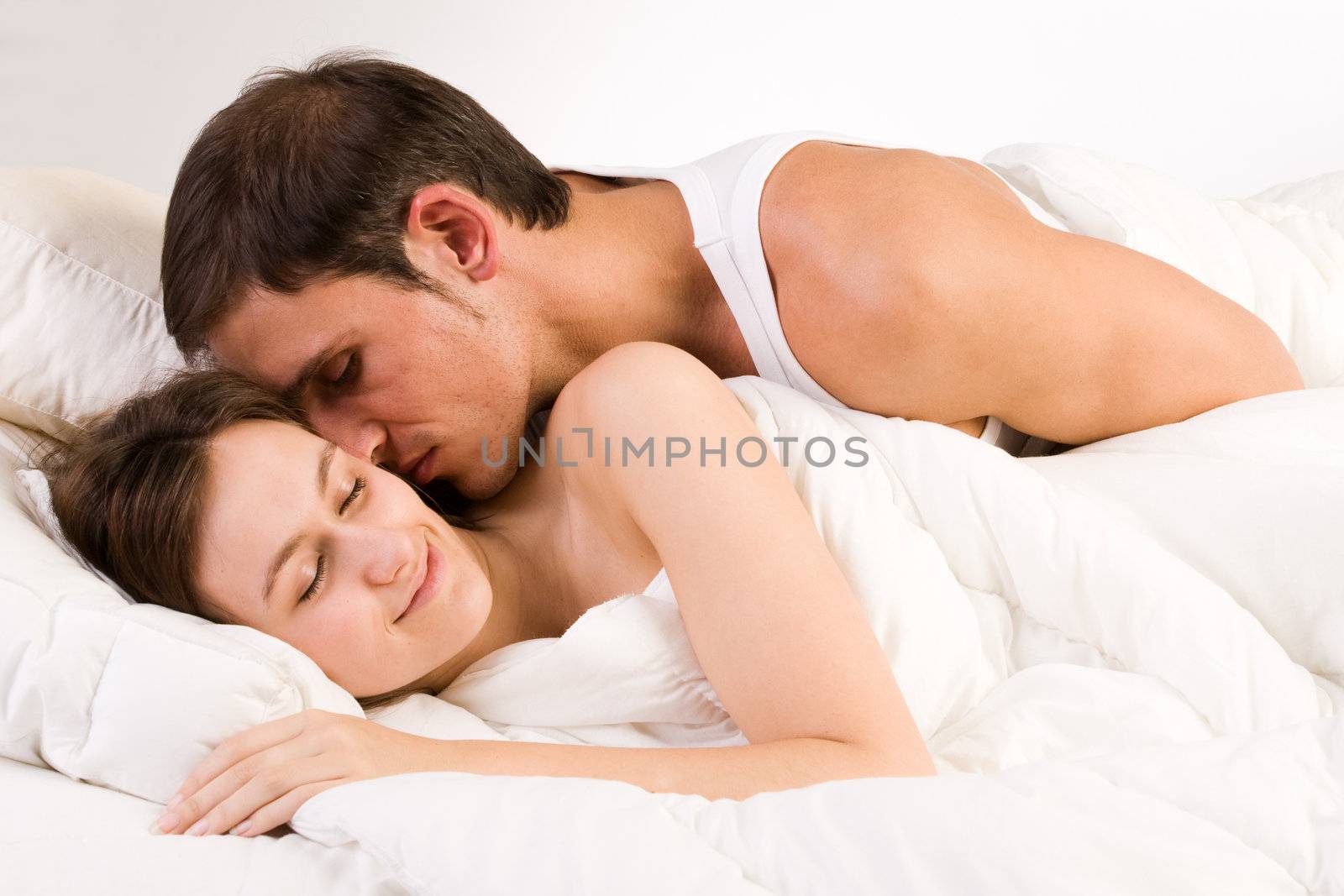 Young adult couple in the studio on a bed
