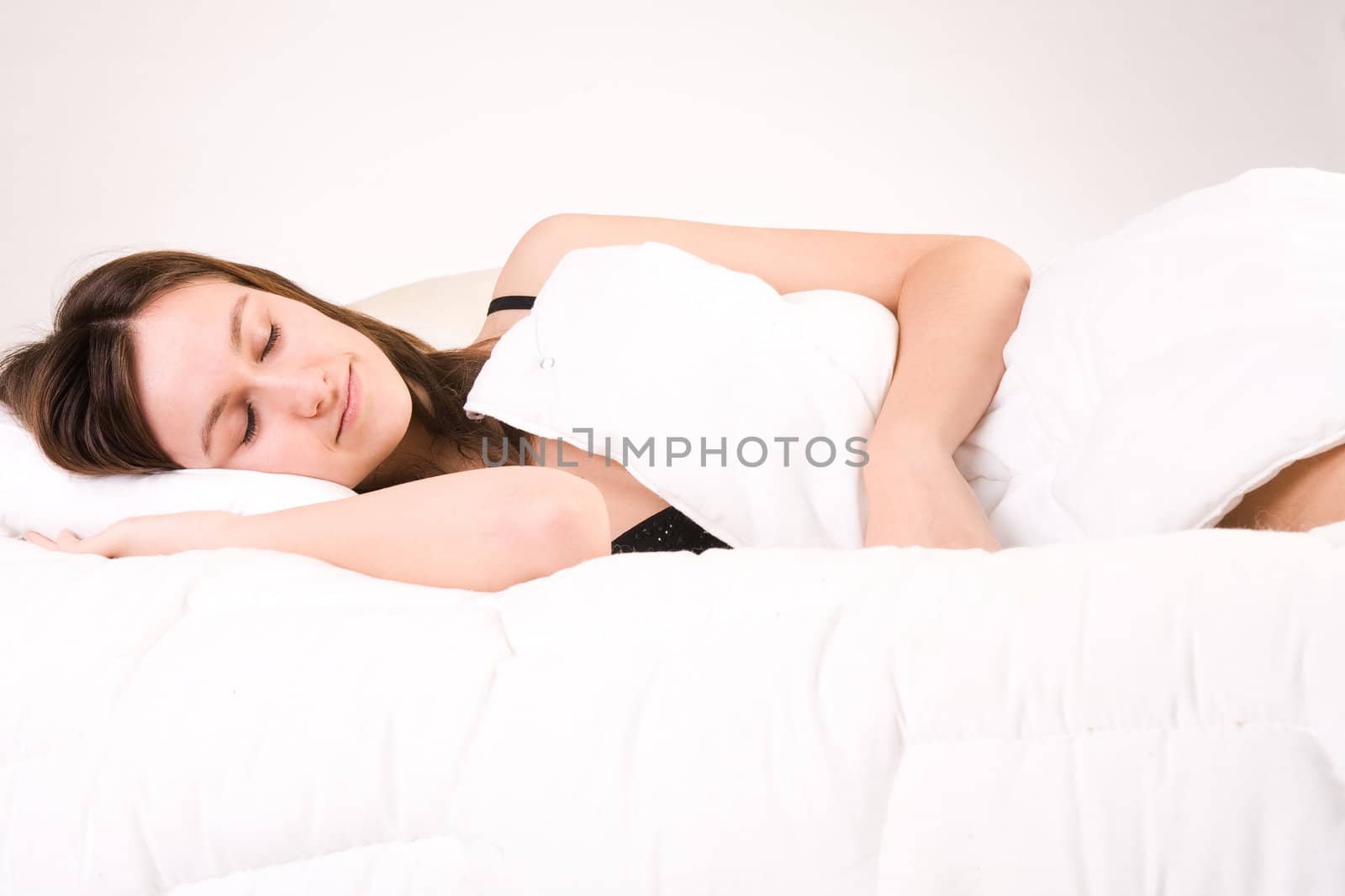 Young adult woman in the studio on a bed