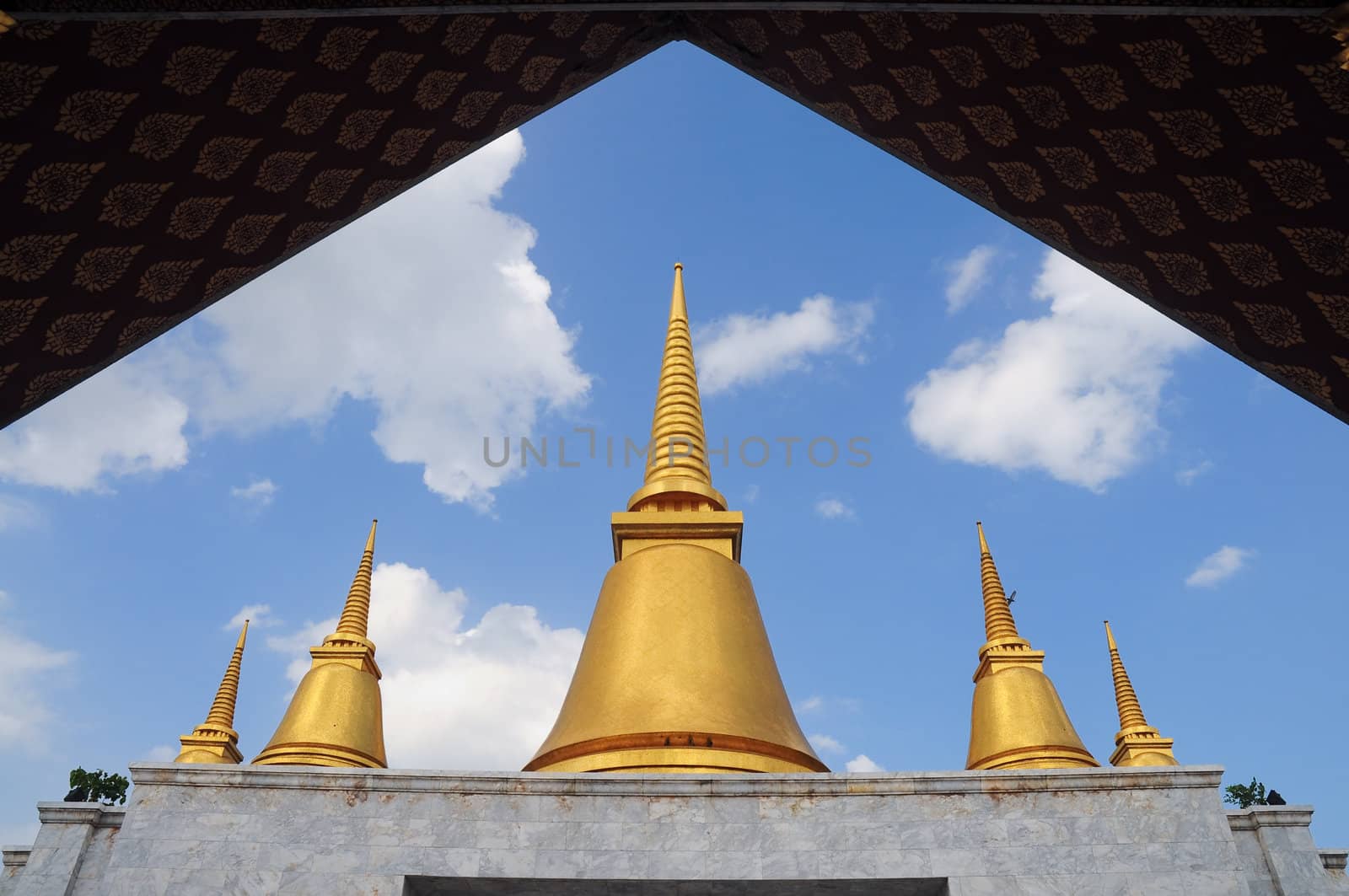 Golden stupa in blue sky by ekawatchaow