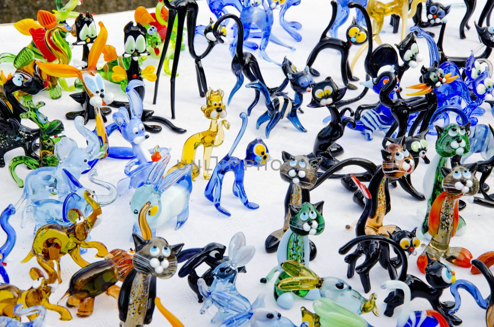 Lots of colorful handmade glass dog, rabbit, cat figures. Beautifully lit in the sun.