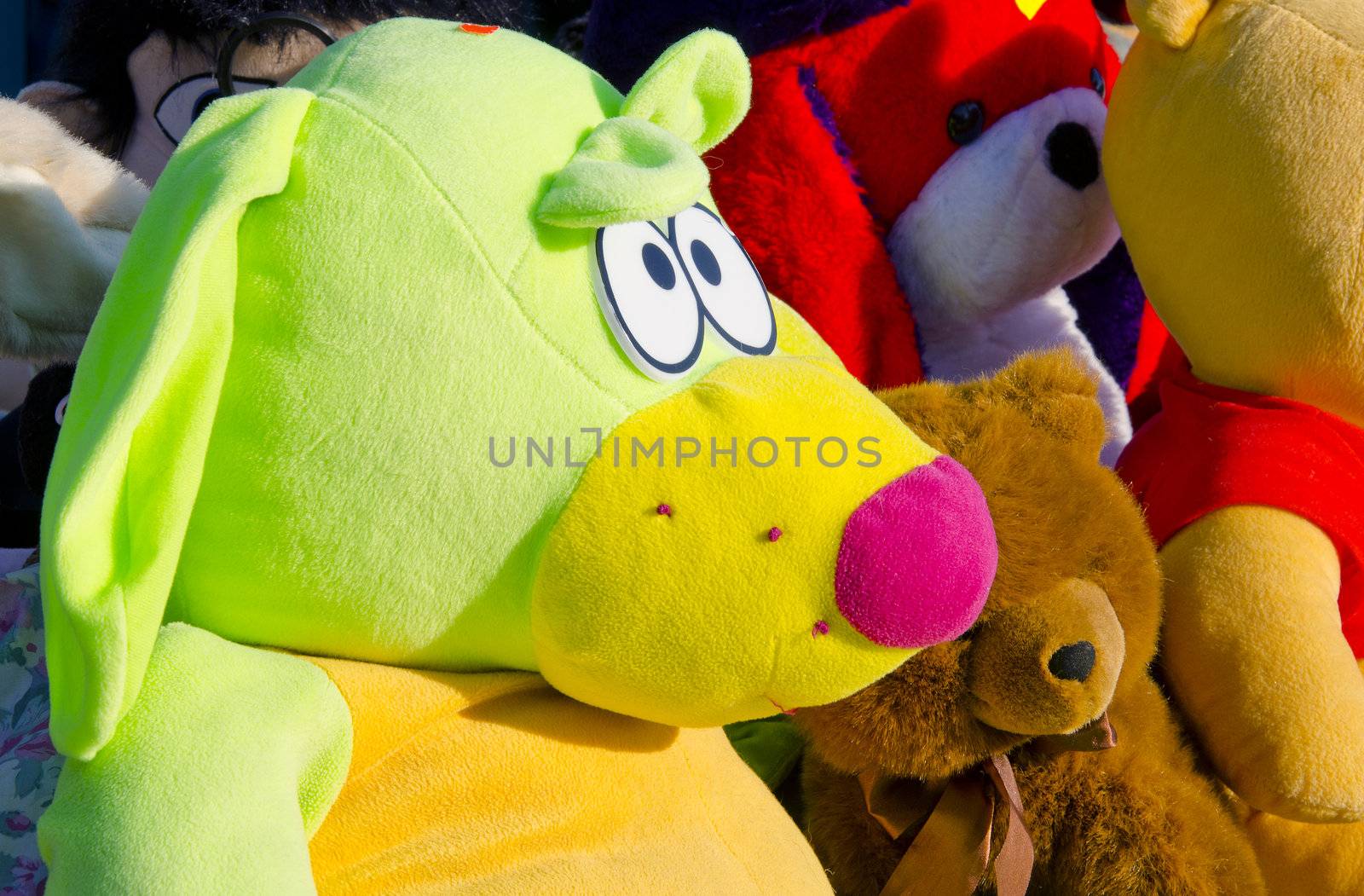 Multicolored material toys sold in fair beautifully lit in the sun.