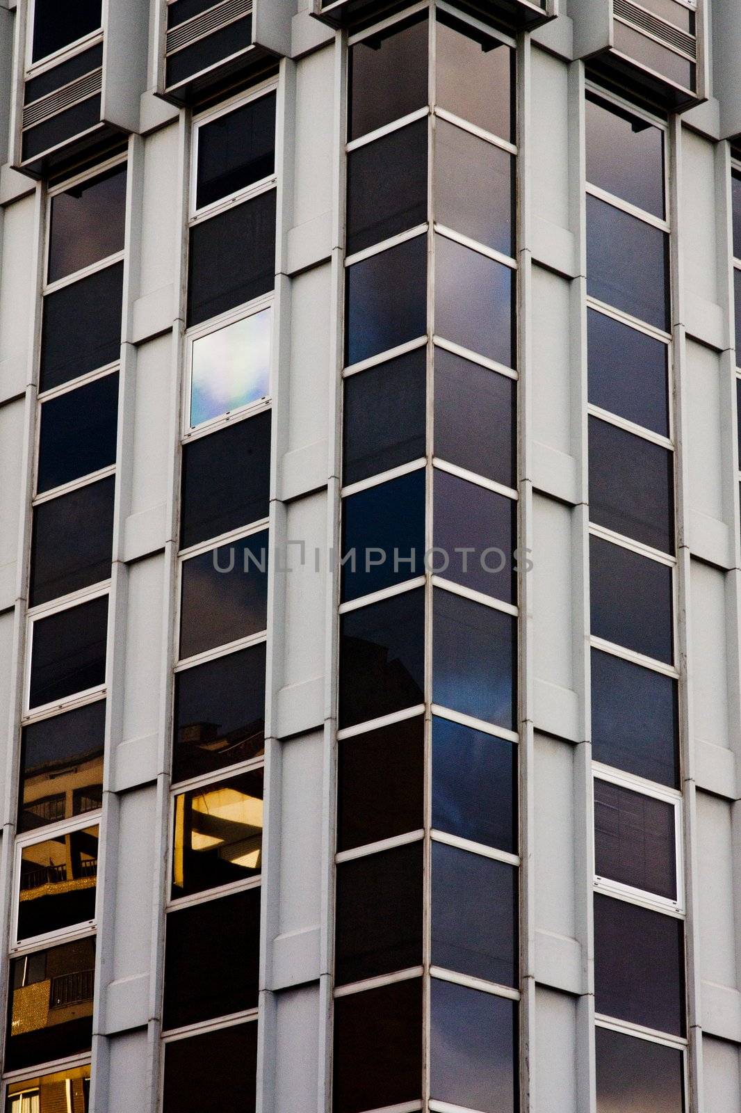 Detail view of the corner of a modern building, with a glowing window.