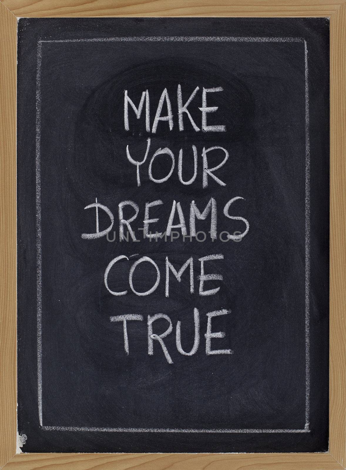 make your dream come true - inspirational phrase on blackboard, white chalk handwriting