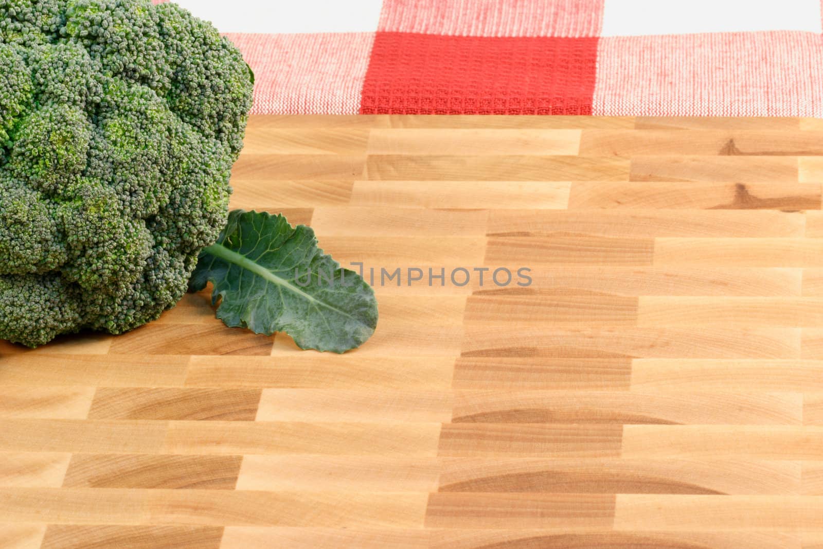 broccoli on fine wood cutting board with tablecloth background 