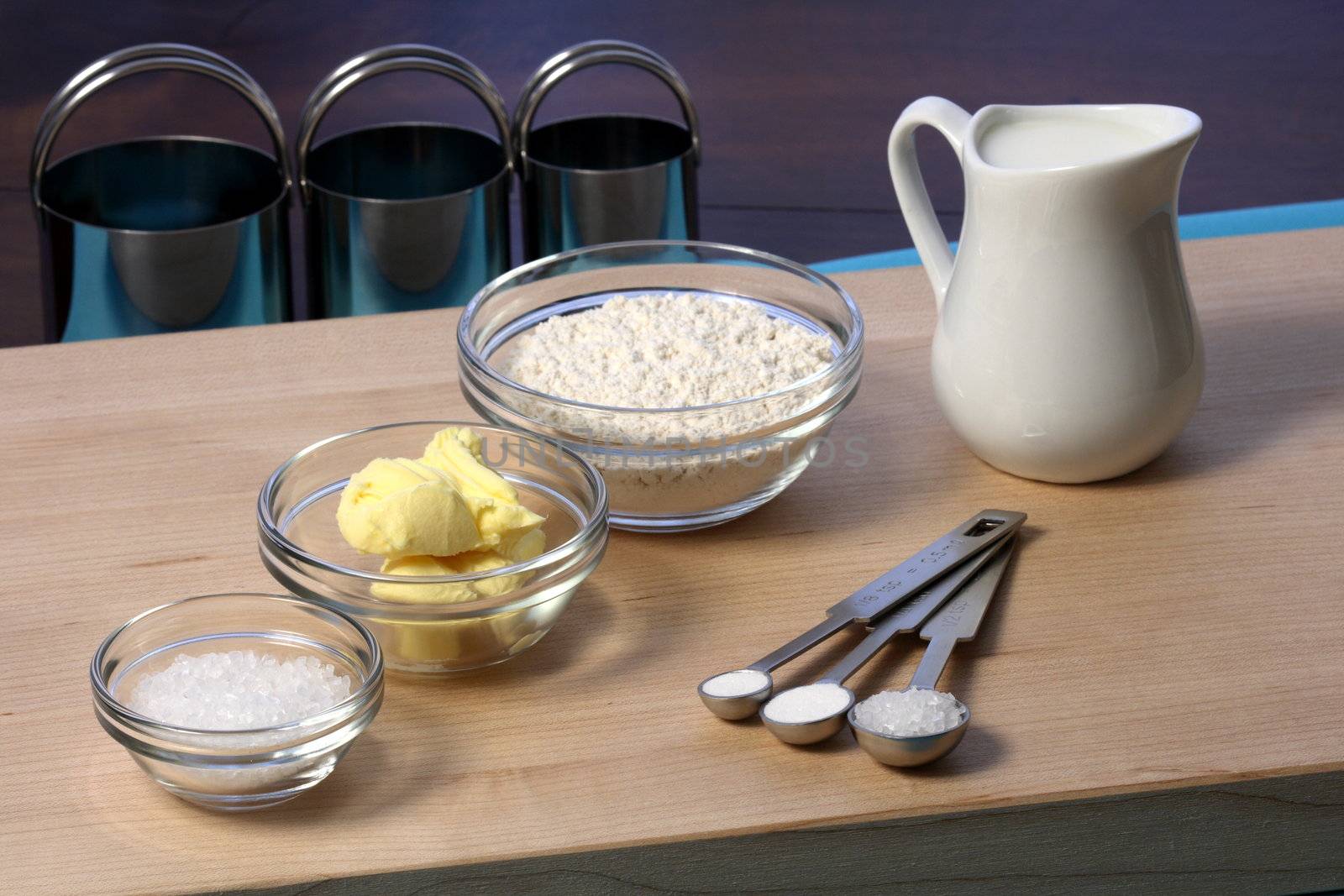 dough ingredients and kitchen utensils on wood cutting board