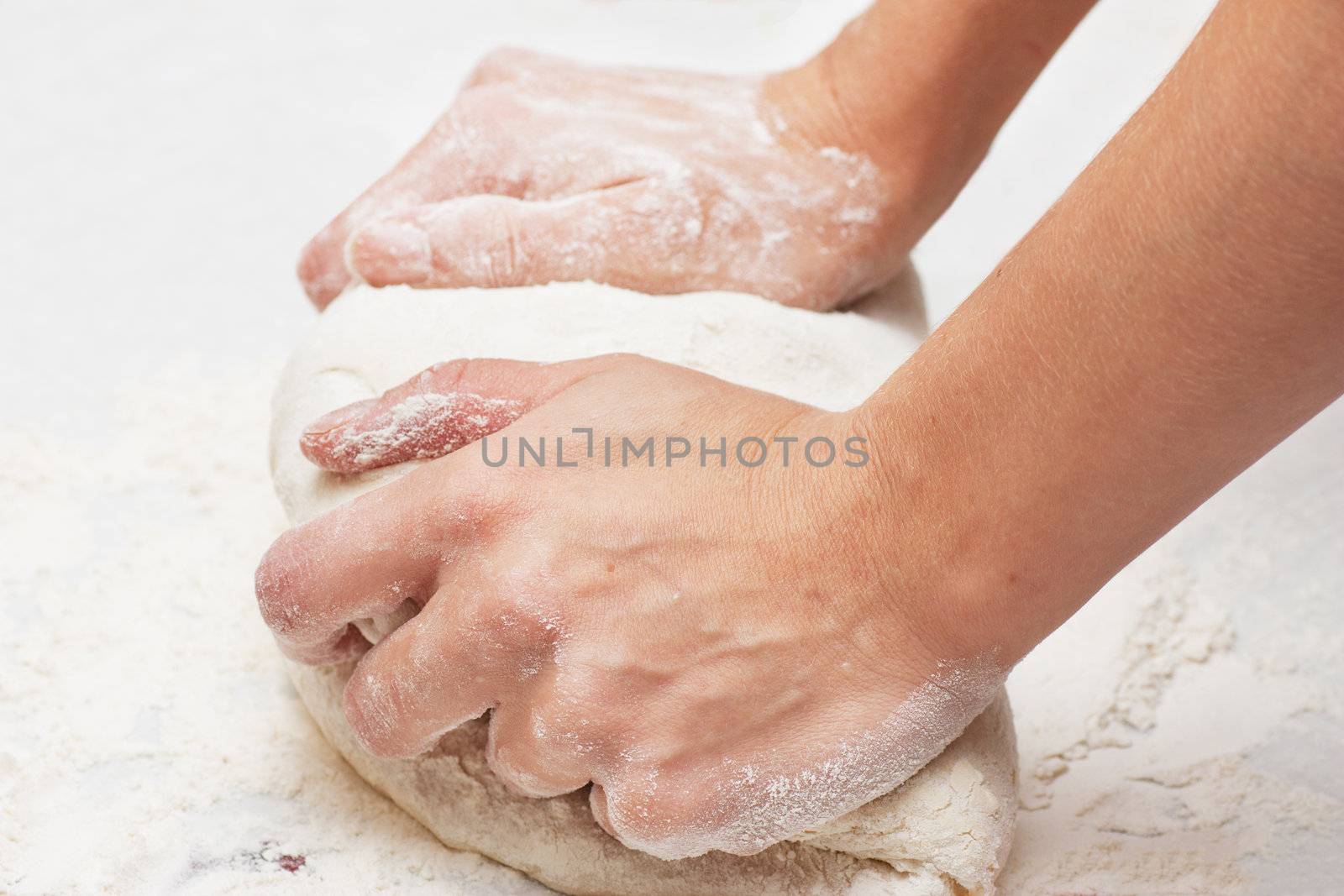 Pair of hands kneading pizza dough.