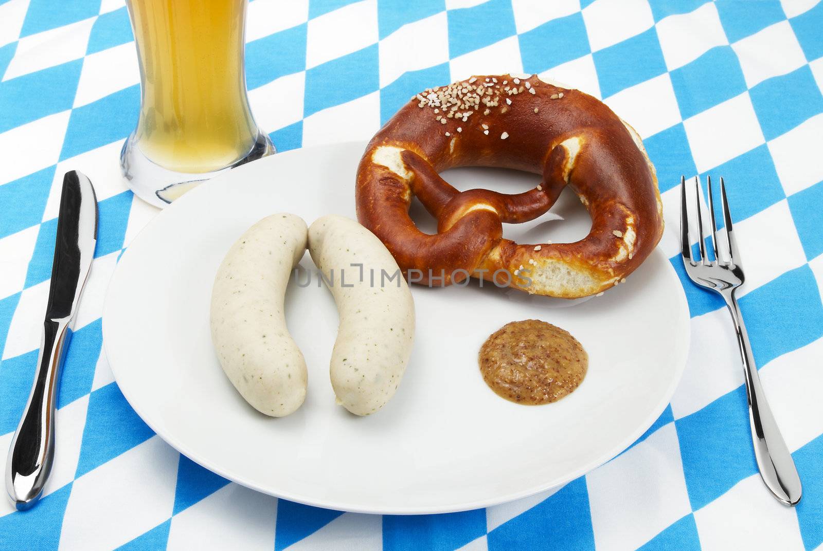 bavarian veal sausage setup with beer and blue white background