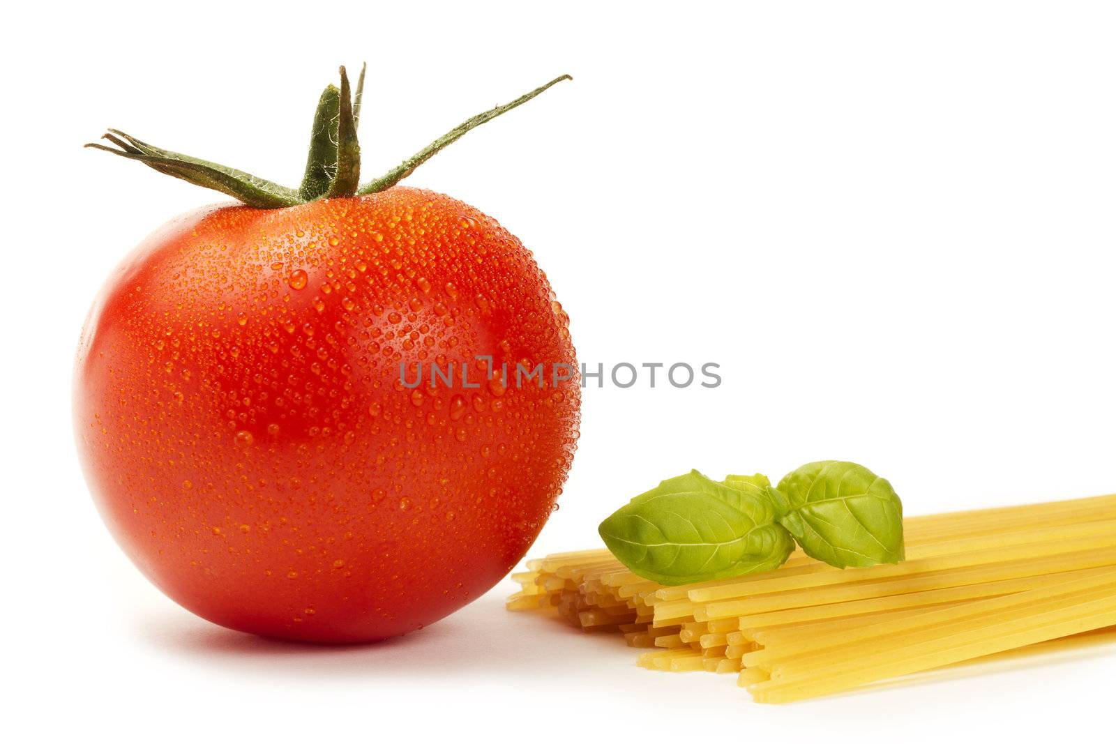 raw spaghetti with wet tomato and basil on white background