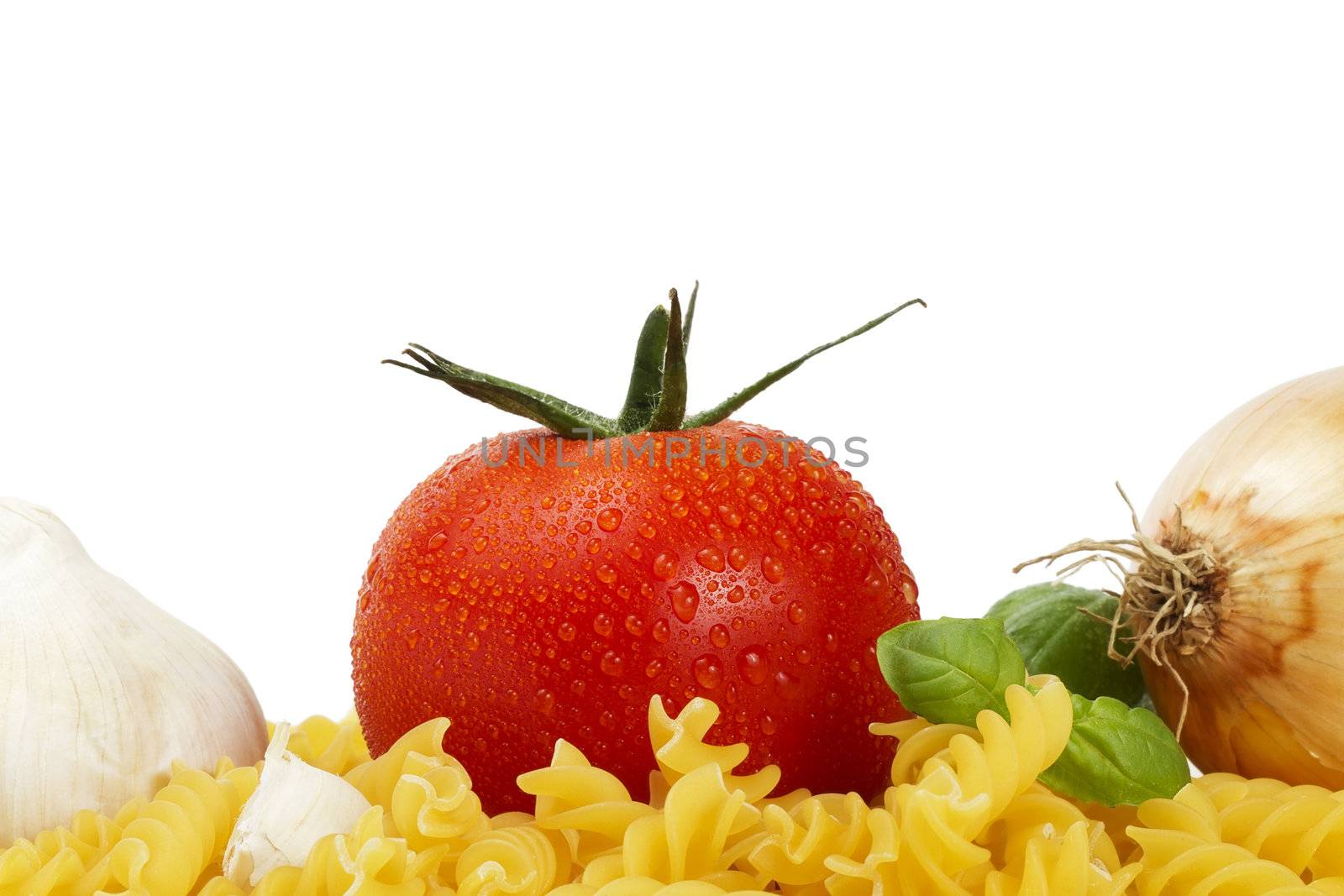 some raw fusilli with tomato, onion, garlic and basil on white background