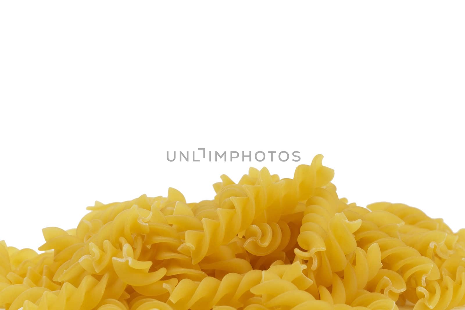 closeup of some raw fusilli on white background