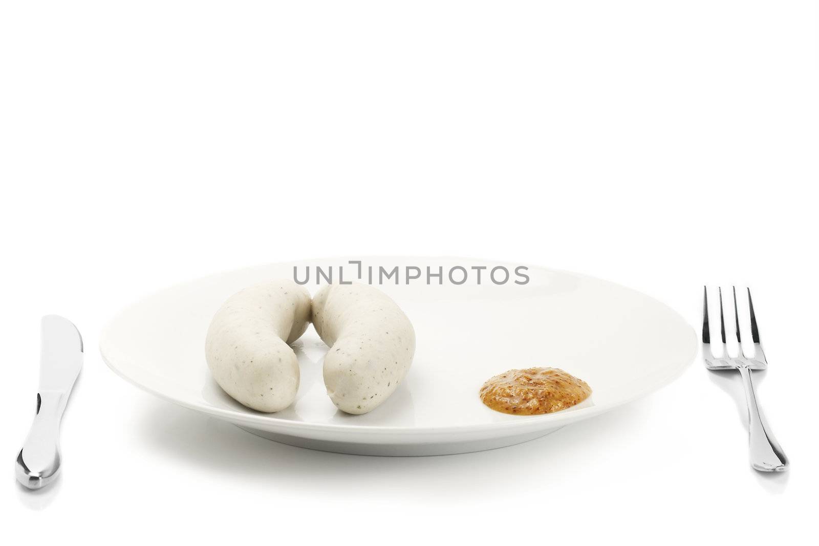 bavarian veal sausages on a plate with sweet mustard on white background