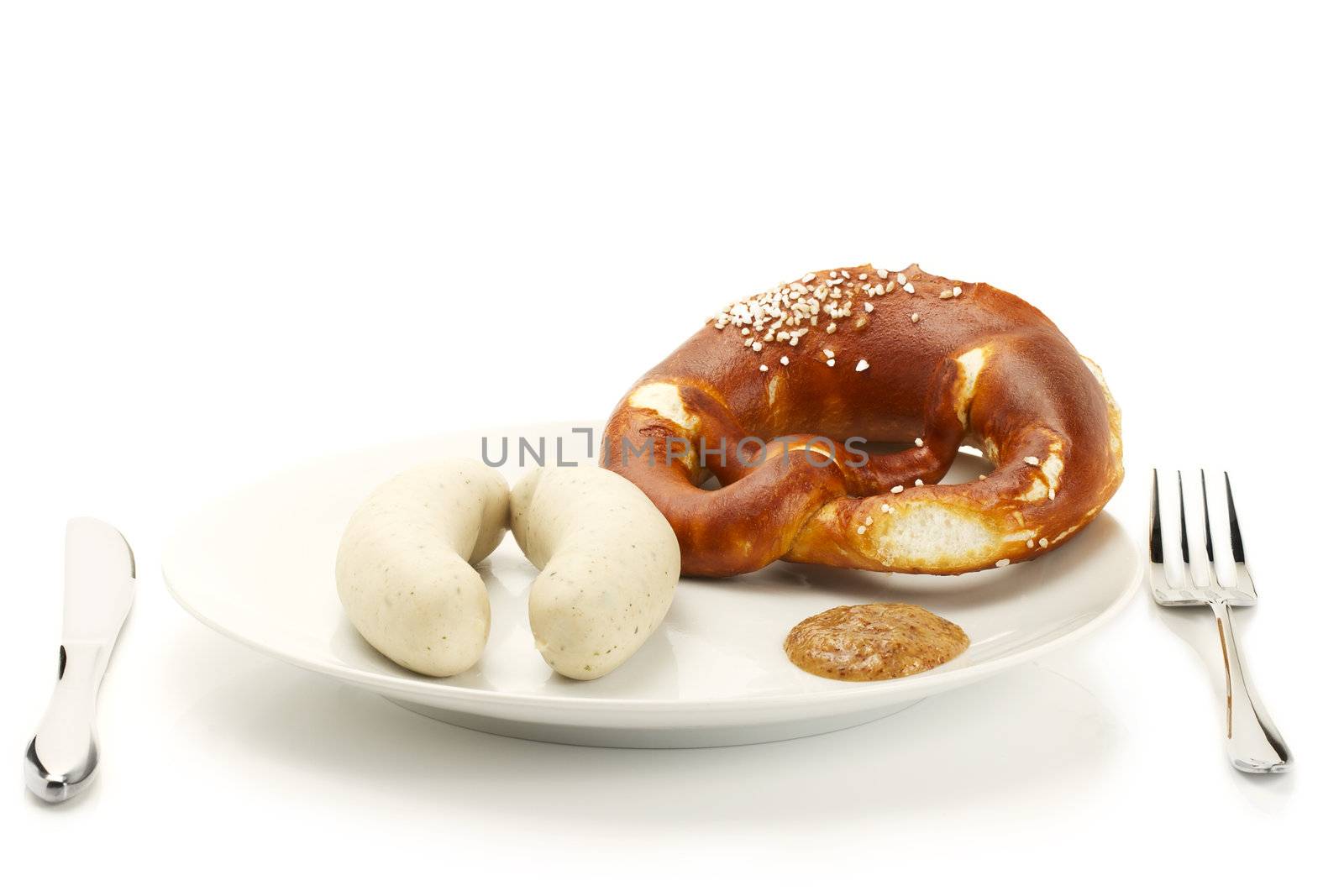 bavarian veal sausages on a plate with sweet mustard and pretzel on white background