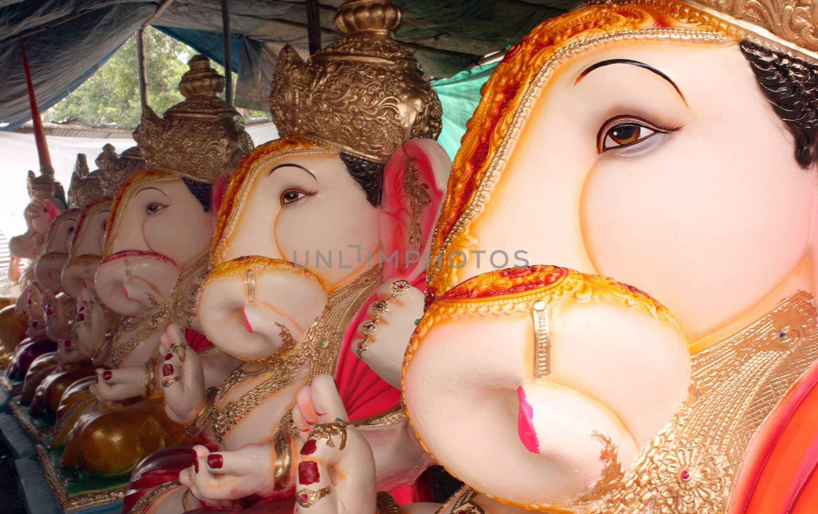 A line of beautiful sculpted lord Ganesha idols for sale in a shop.