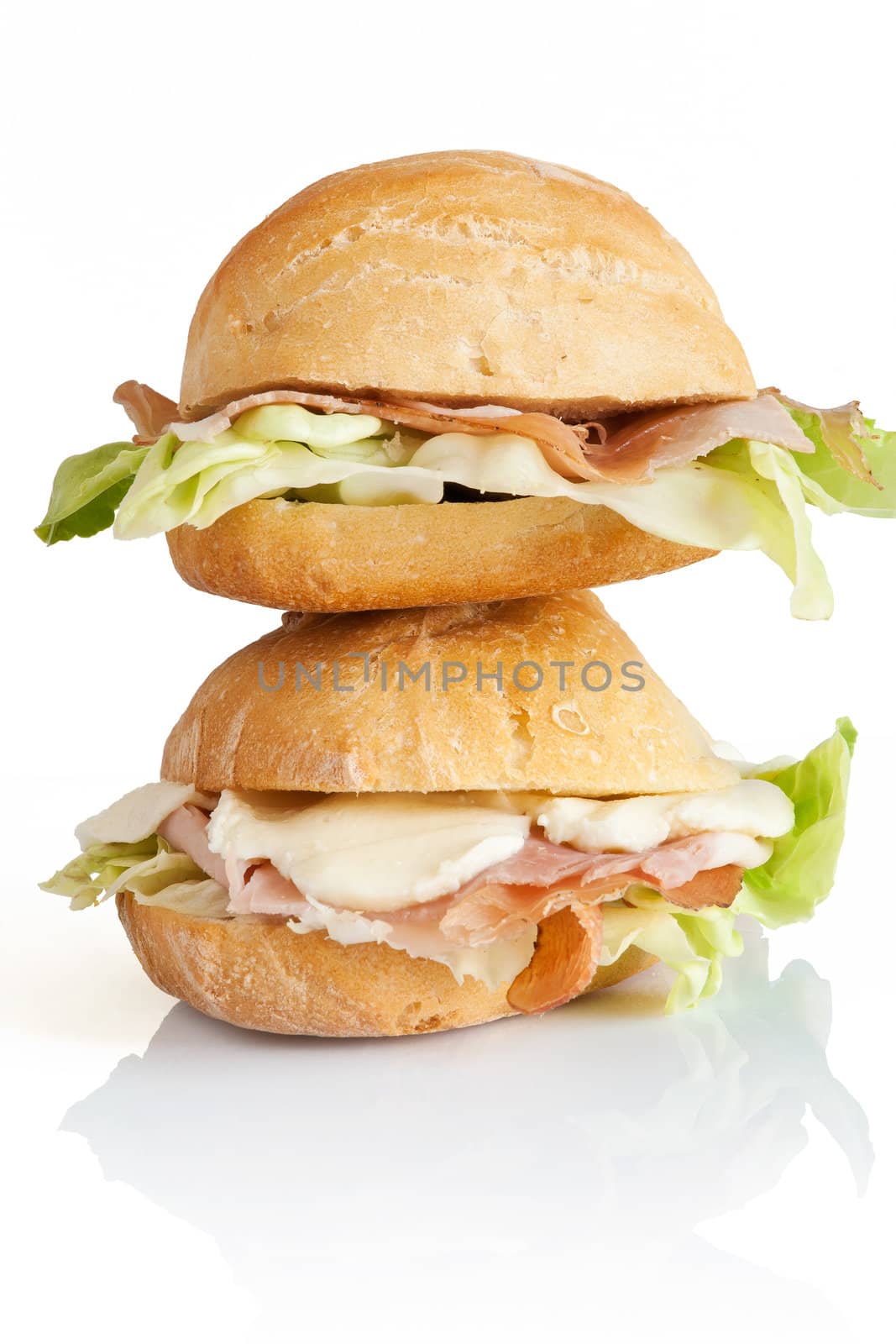 two sandwiches with ham, lettuce and mozzarella isolated on white background with clipping path