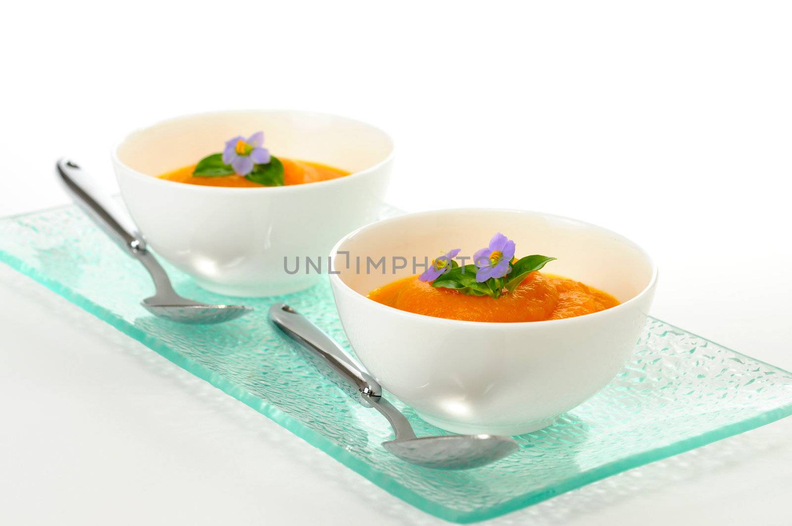 Delicious carrot soup garnished with edible flowers.