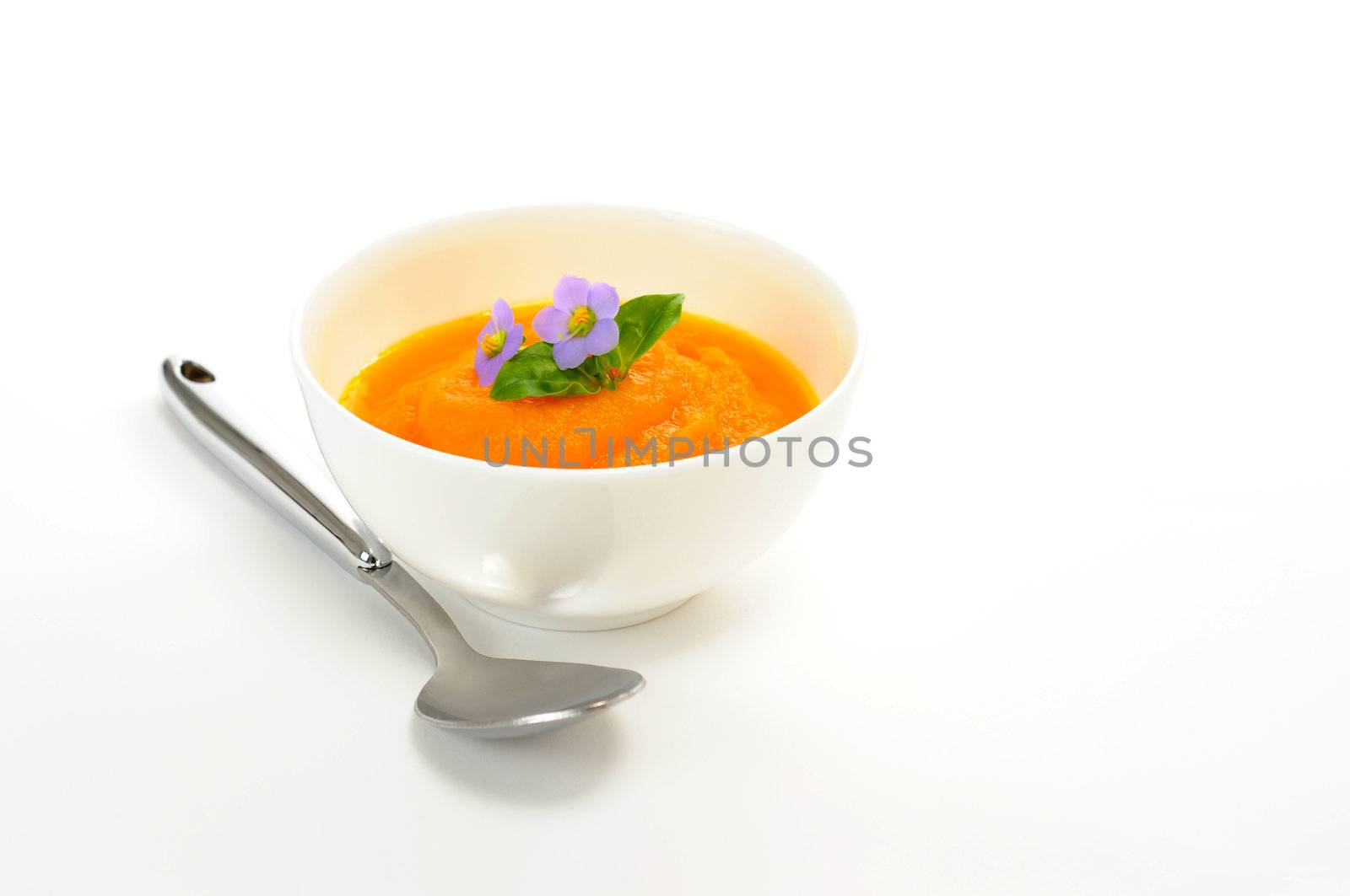 Delicious homemade carrot soup with edible flower garnish.