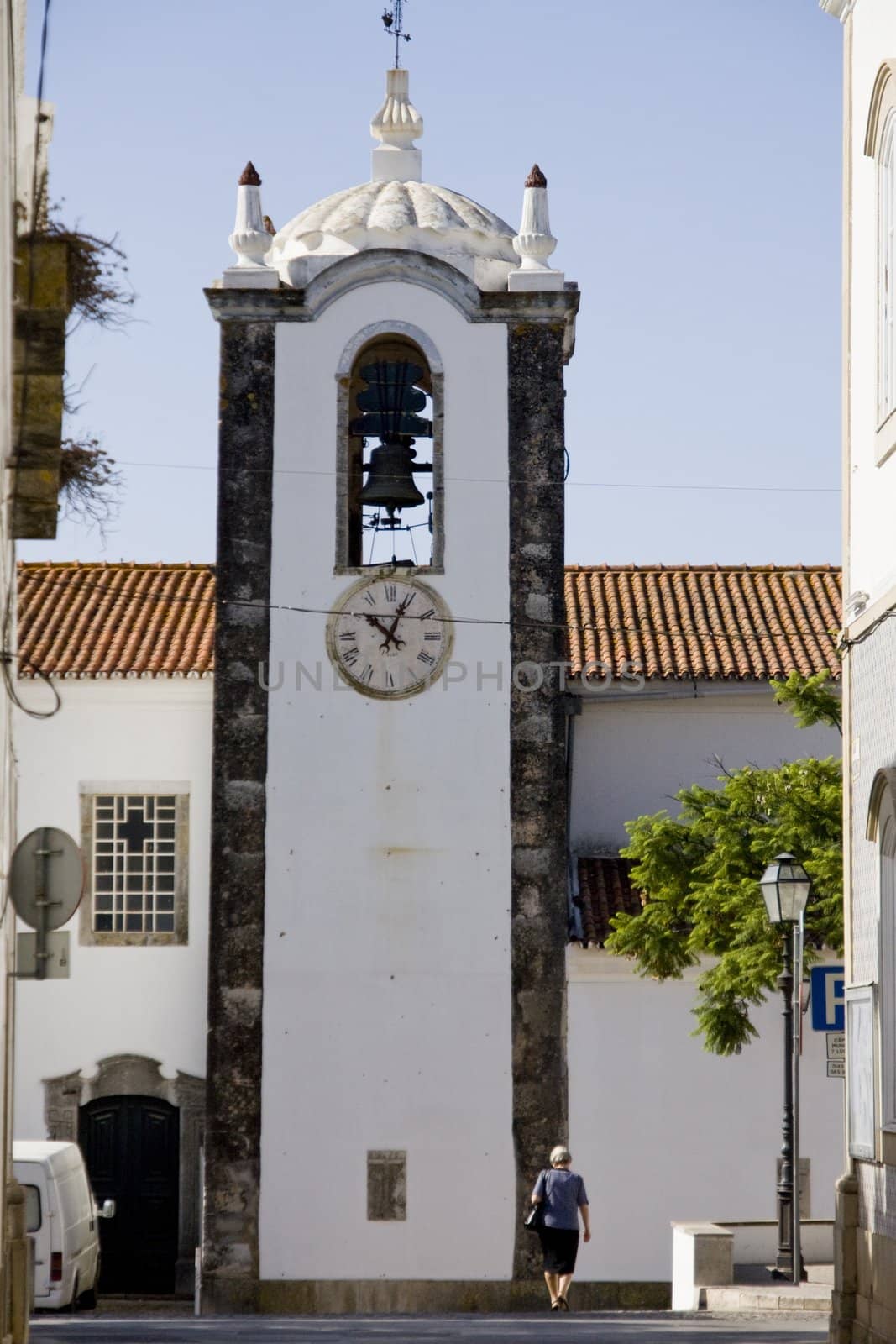 View of a woman walking down to street in the path to the church.