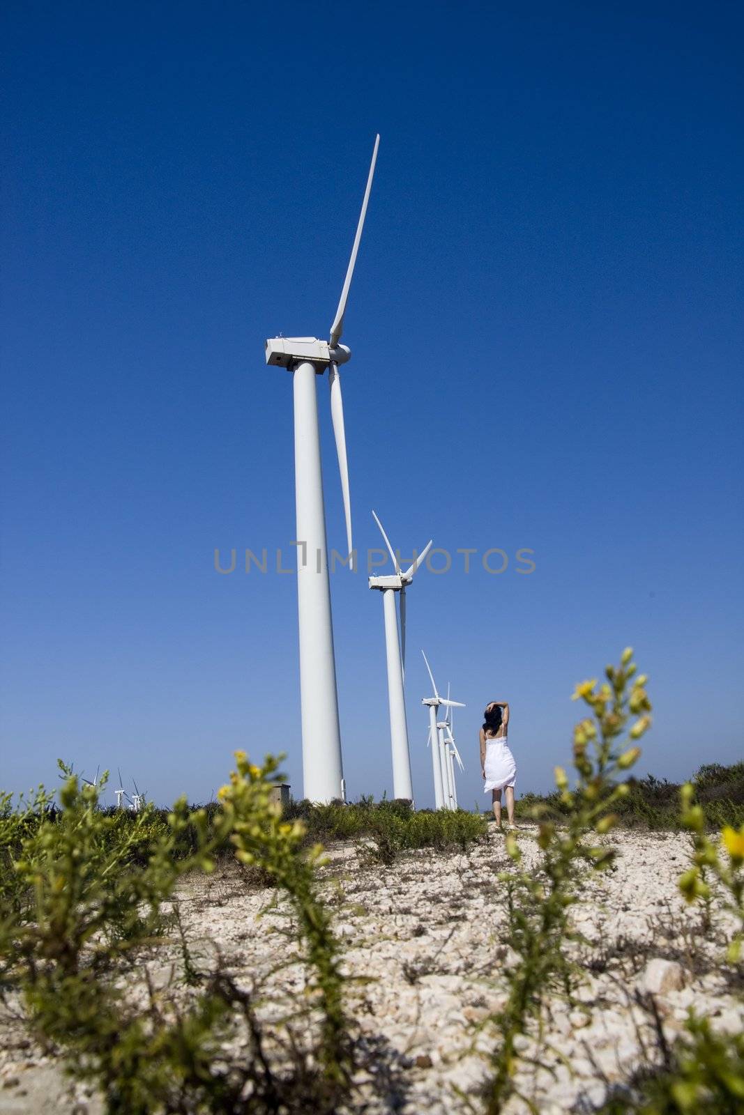 View of a young girl watching a windmill.