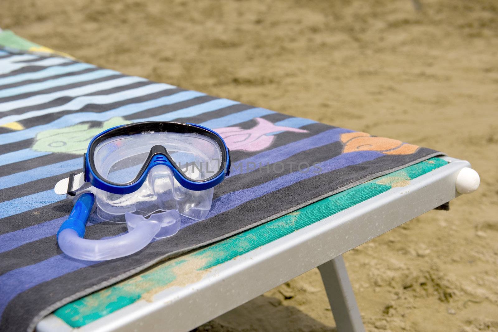 a mask on a towel and a beach chair