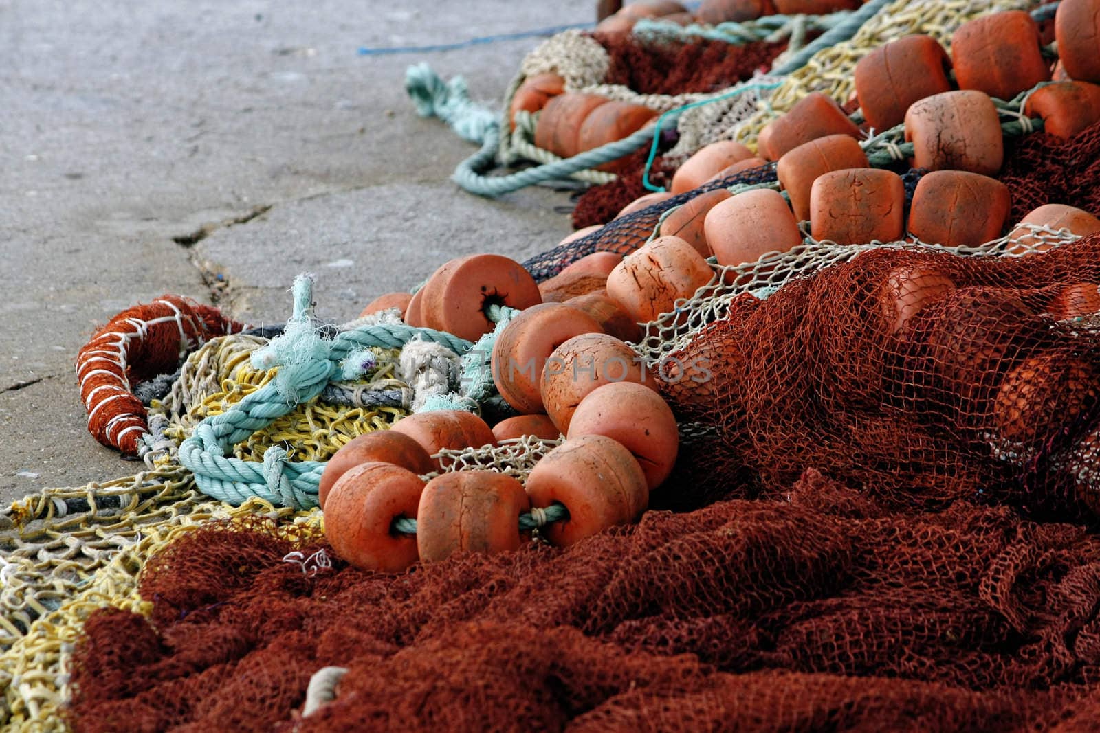 Close view of several fishing gear on the floor, including floaters and nylon string.