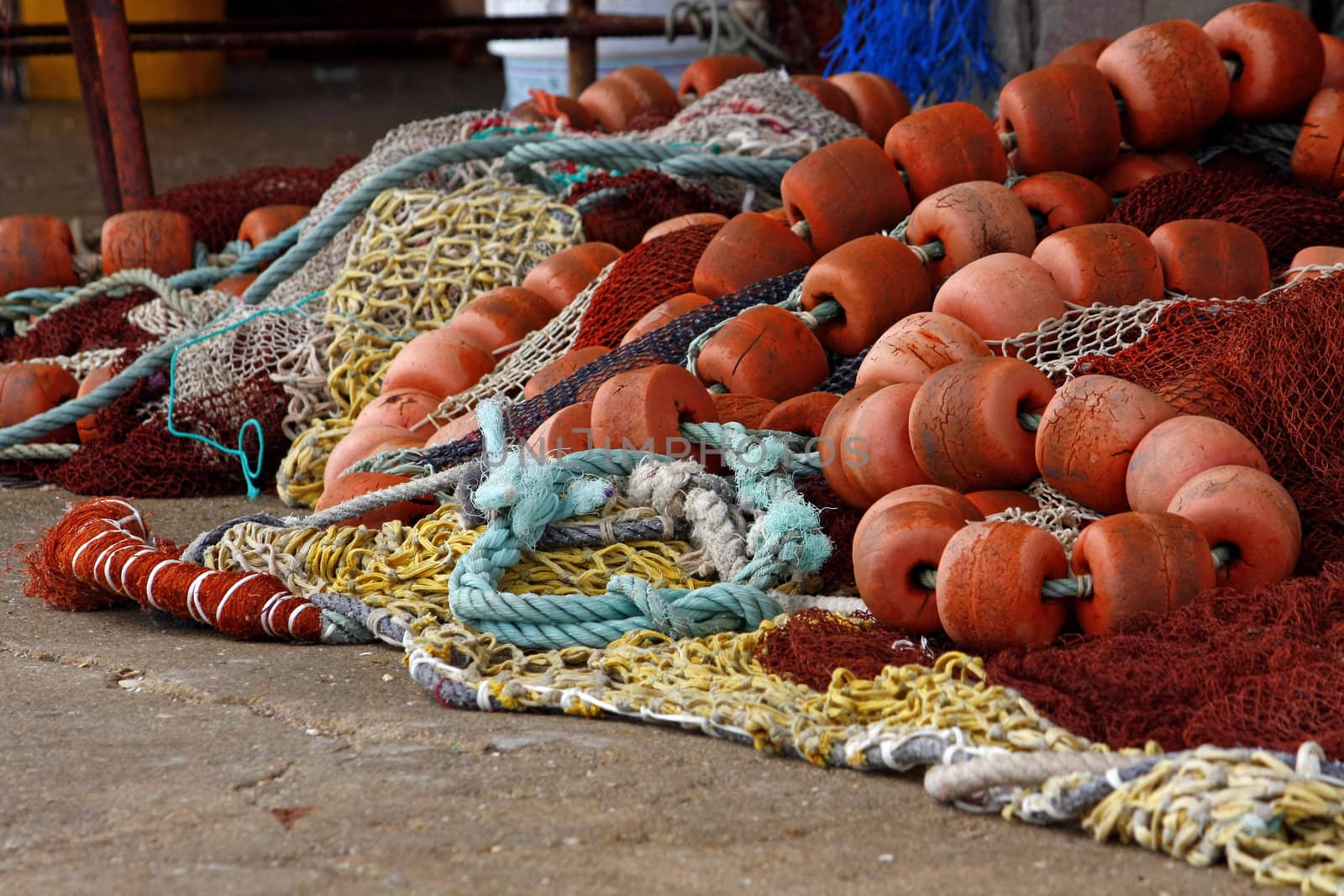 Some pile of fishing gear, including, nylon string, ropes, floaters on the floor.