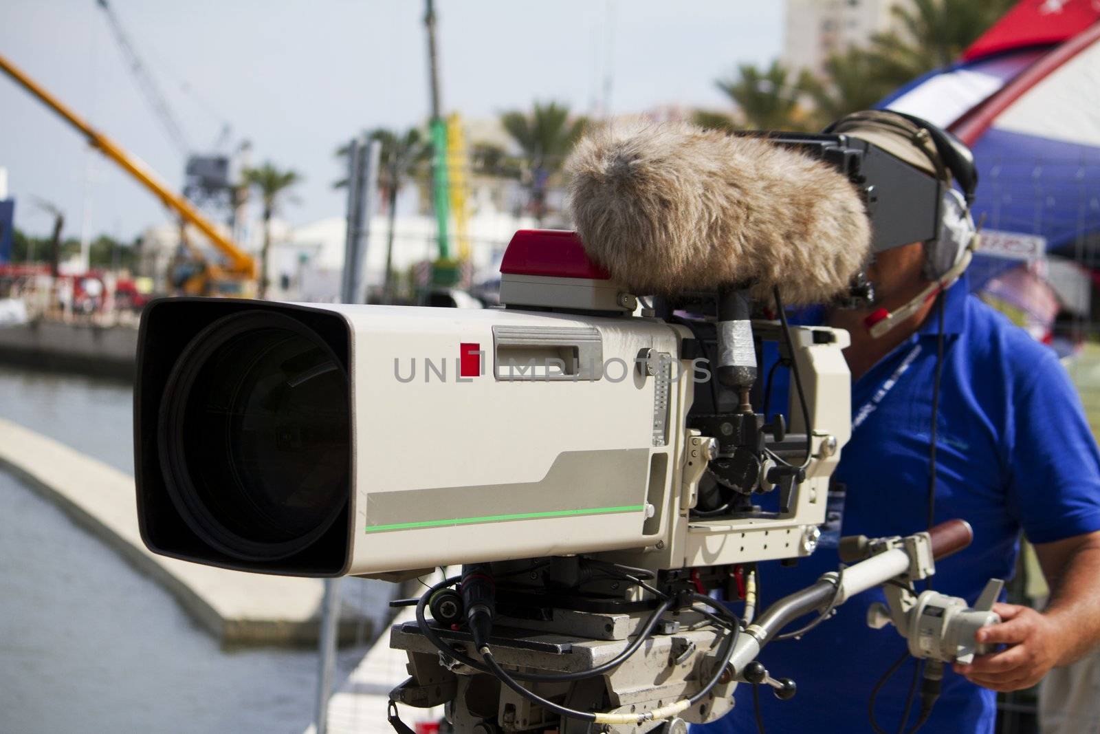 Close view of a professional cameraman filming a sports event.