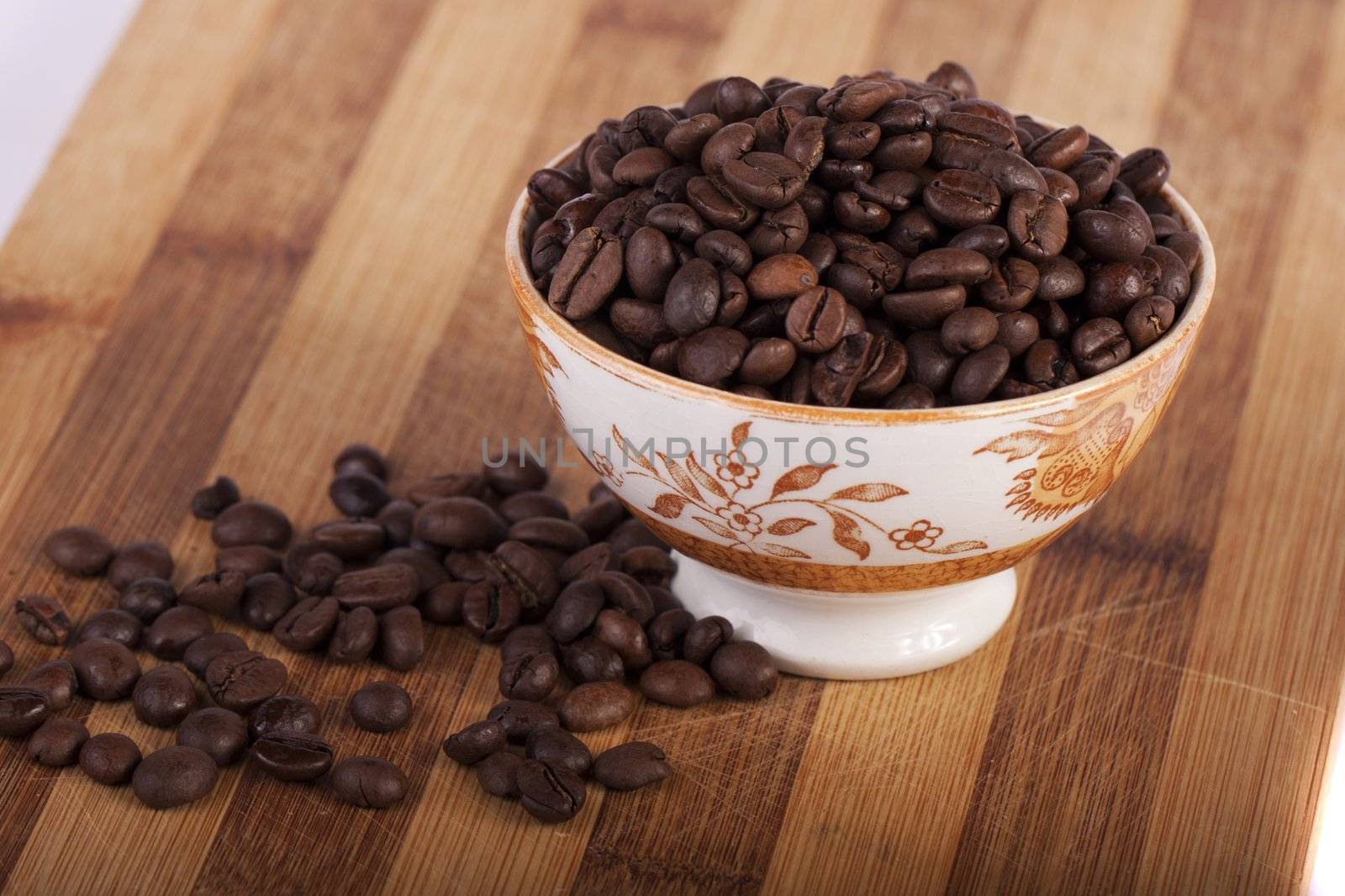 Close view of a bunch of roasted beans of coffee inside a bowl.