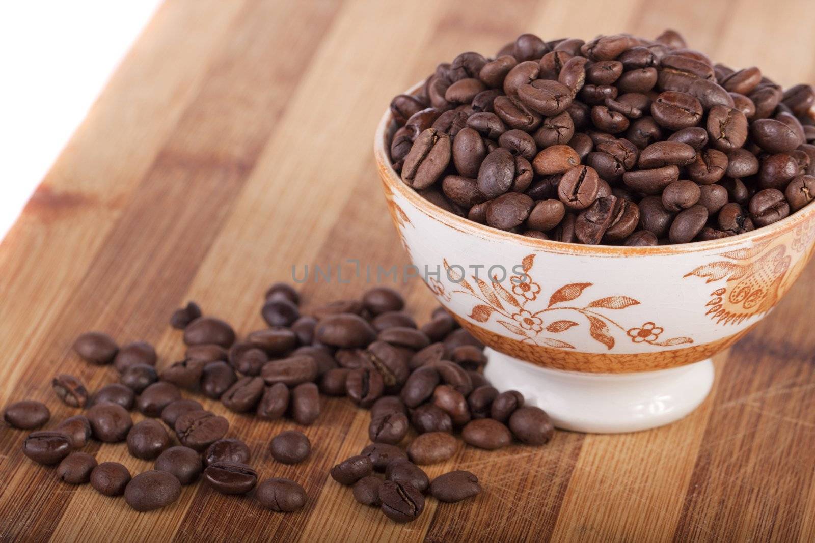 Close view of a bunch of roasted beans of coffee inside a bowl.