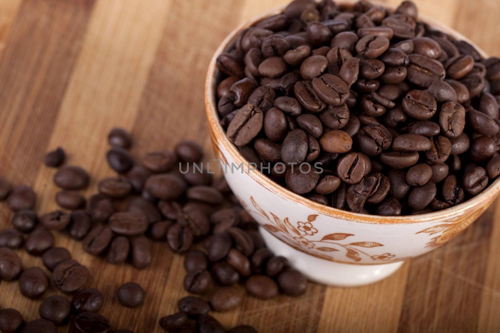 Close view of a bunch of roasted beans of coffee inside a bowl.