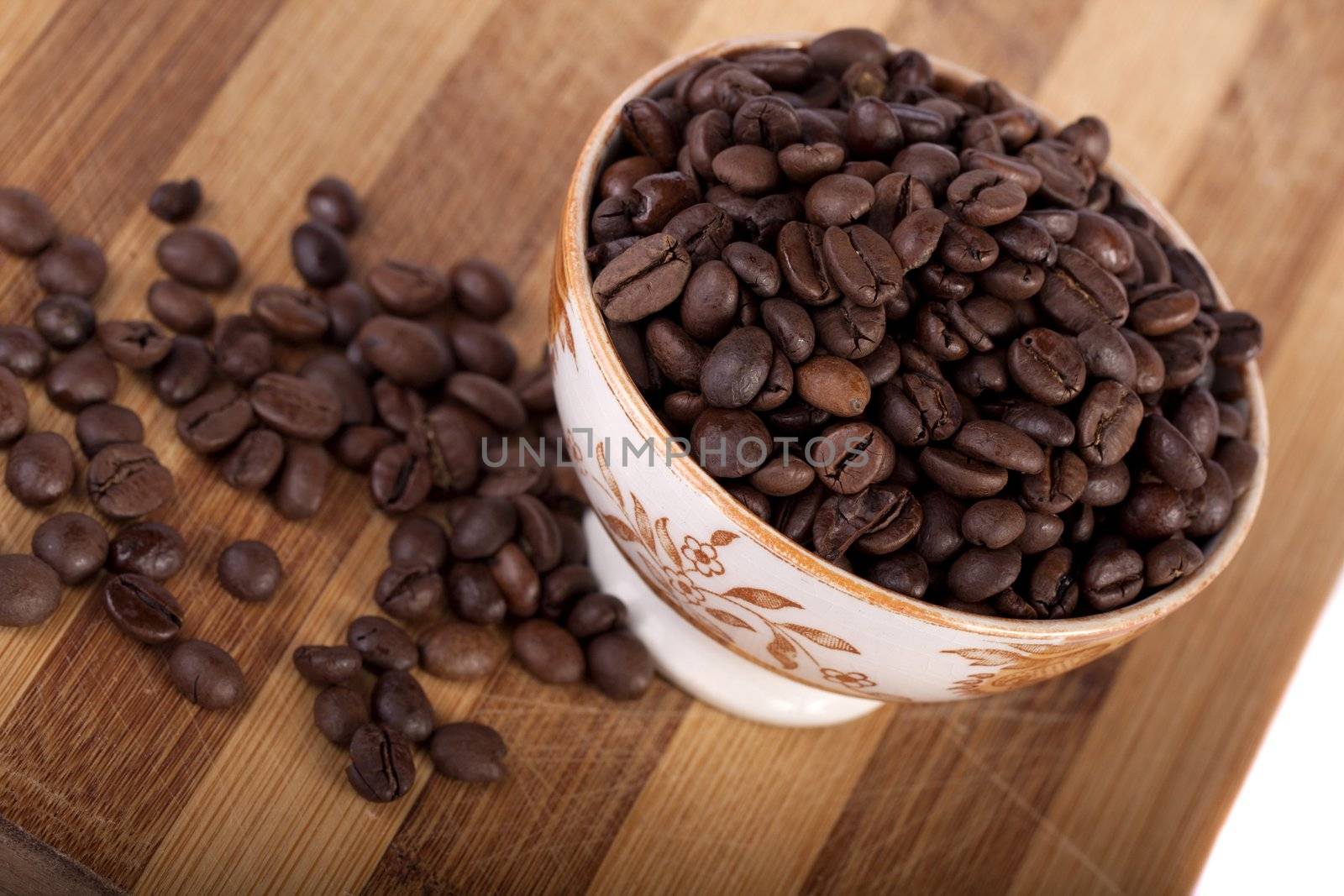 Close view of a bunch of roasted beans of coffee inside a bowl.