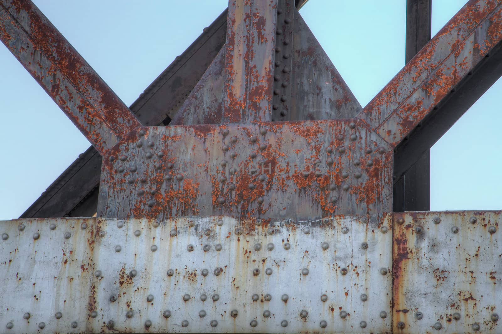 Framework of rusty old steel beams and girders with backdrop sky