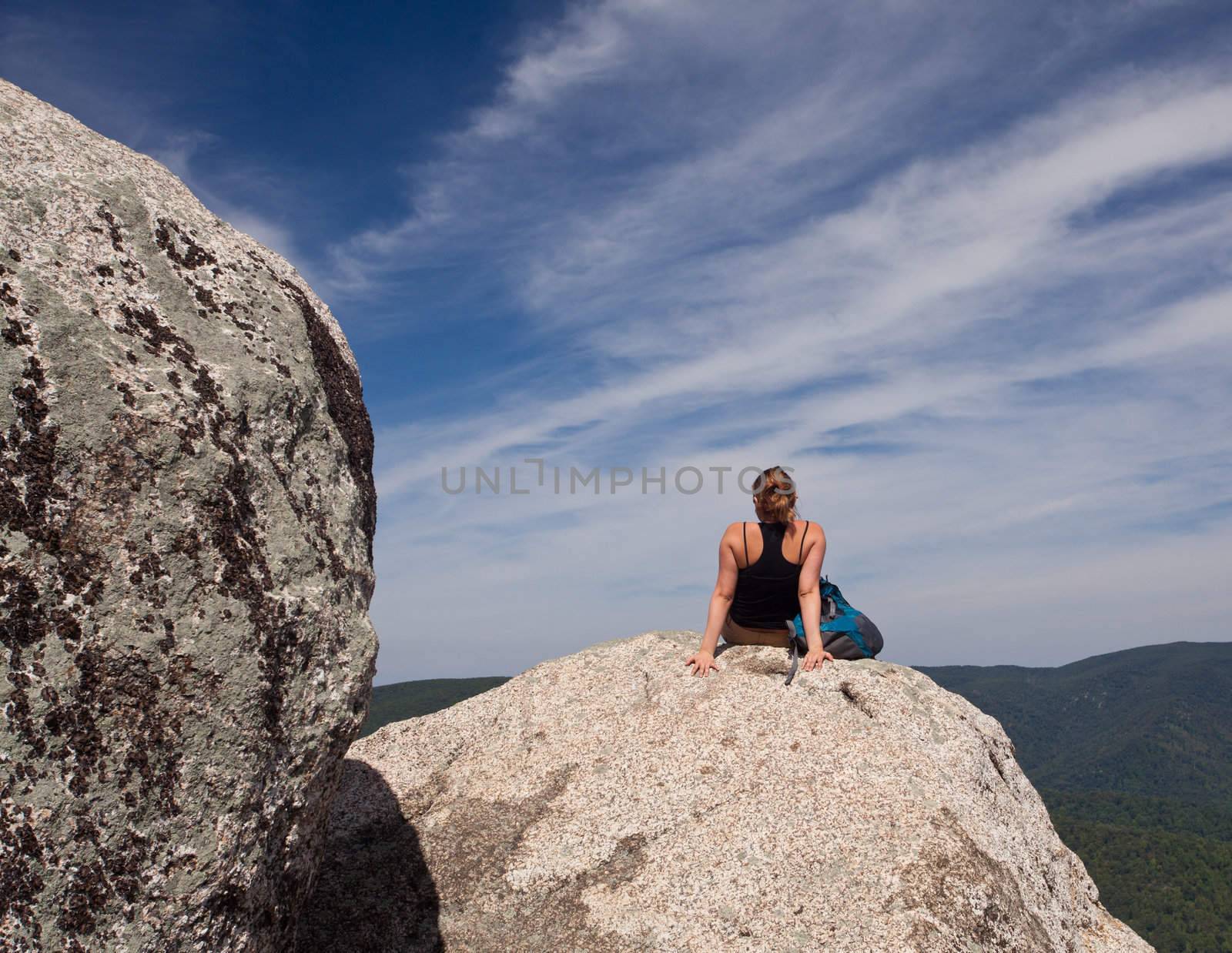 Female hiker looks over valley in the Shenandoah on a climb of Old Rag