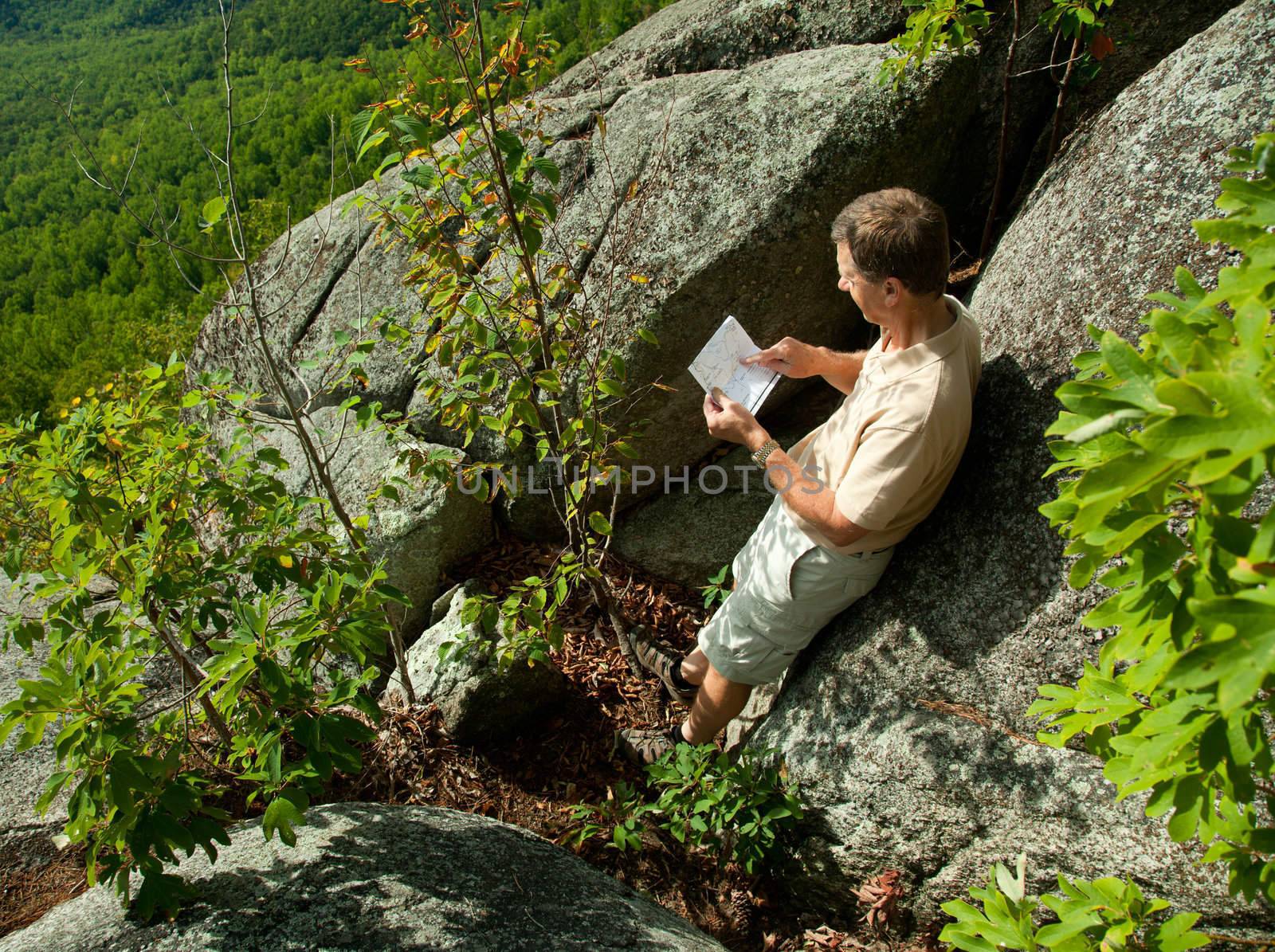Senior hiker looks at map in the Shenandoah on a climb of Old Rag