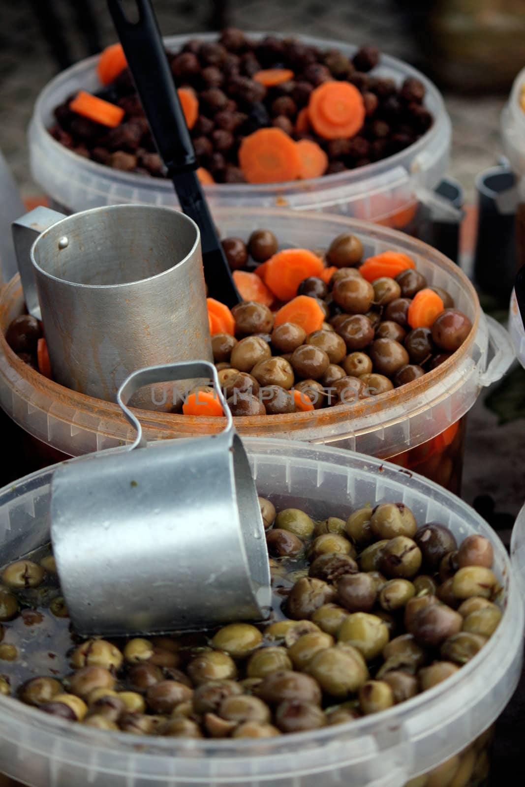 View of some containers on a street marked selling olives.