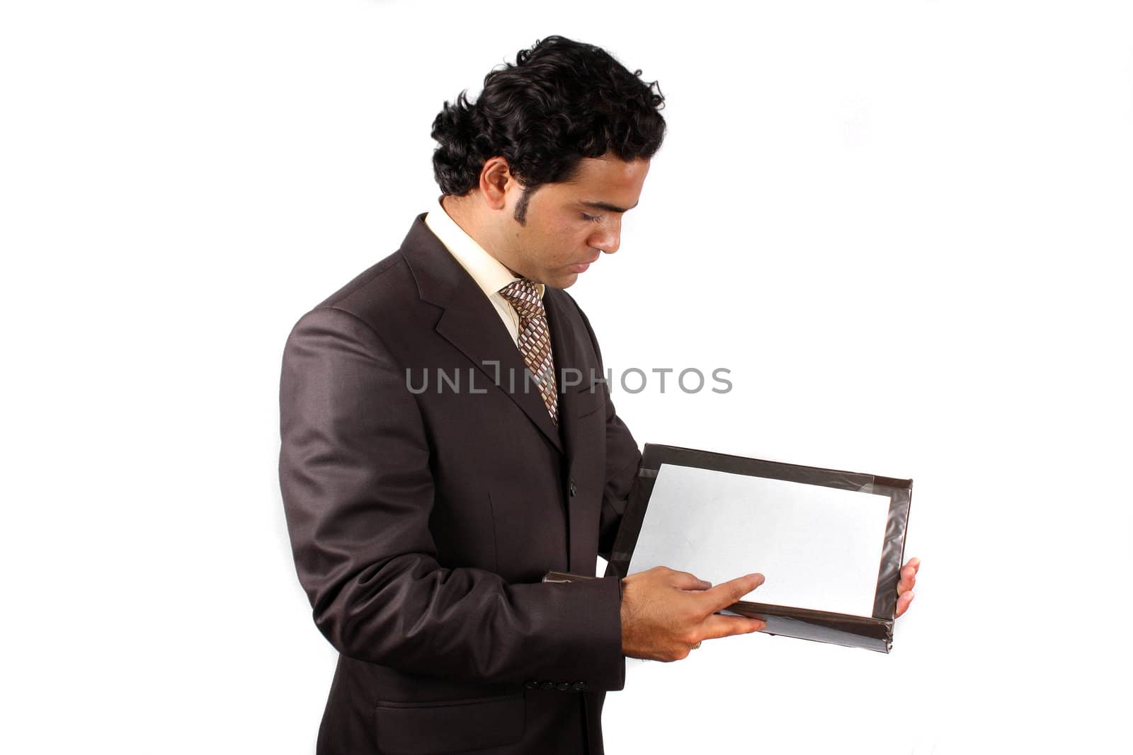 A young Indian businessman checking contract documents, on white studio background.