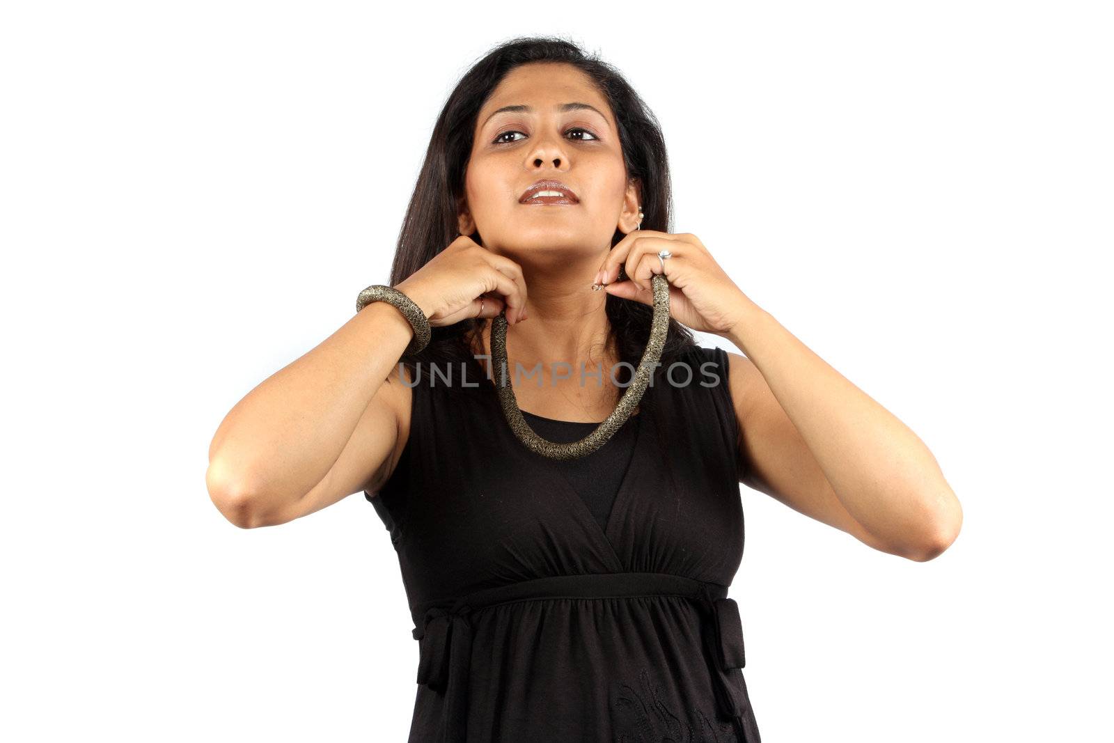 A young Indian lady wearing a fashionable necklace, on white studio background.