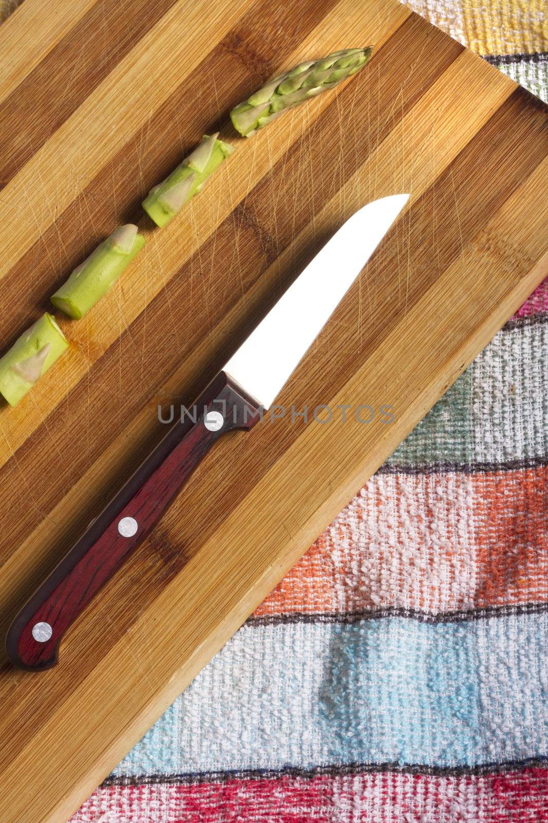 Close view detail of an asparagus vegetable sliced on a wooden board.