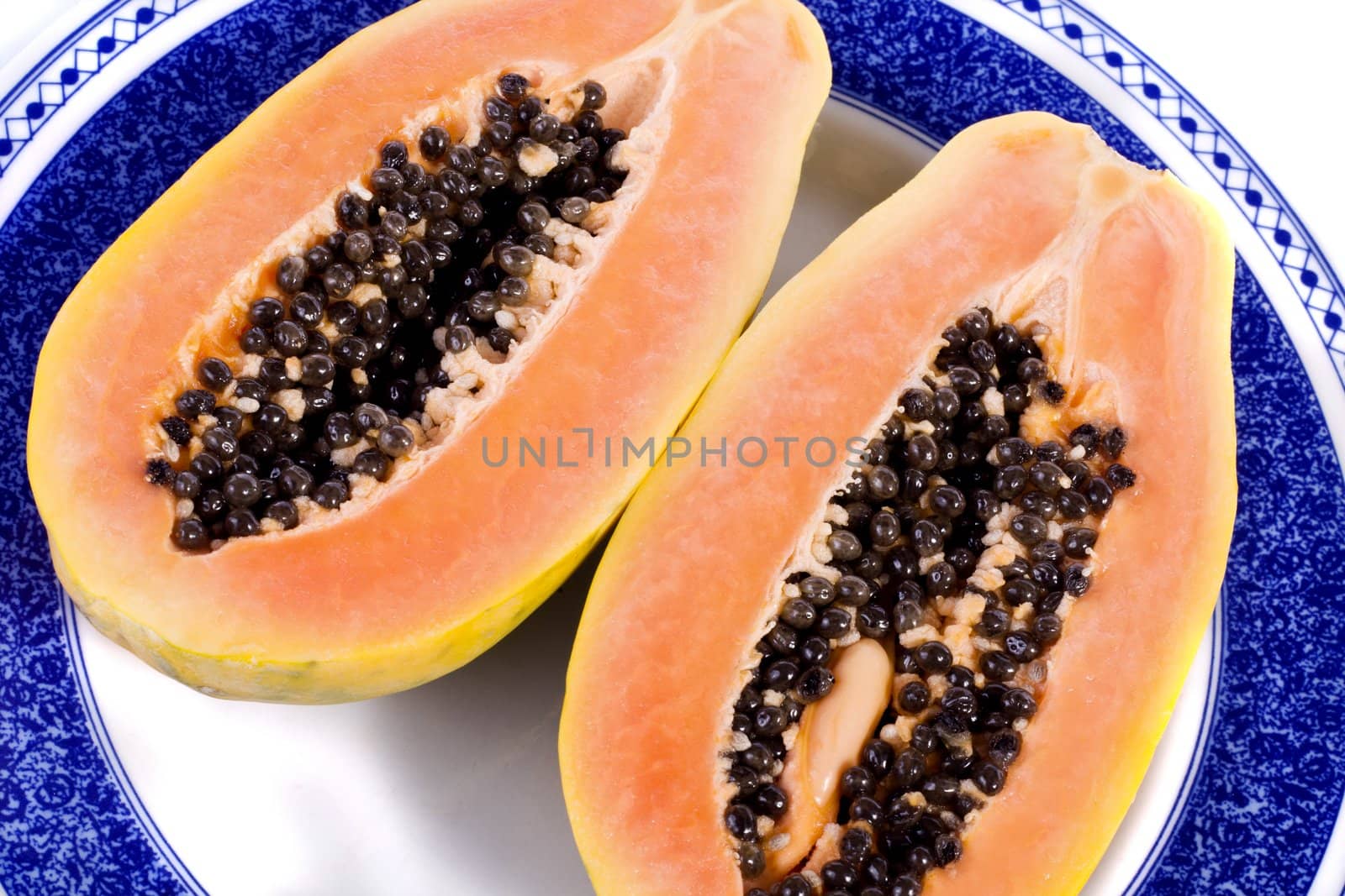 Close up view of papaya fruit sliced presented on a dish. 