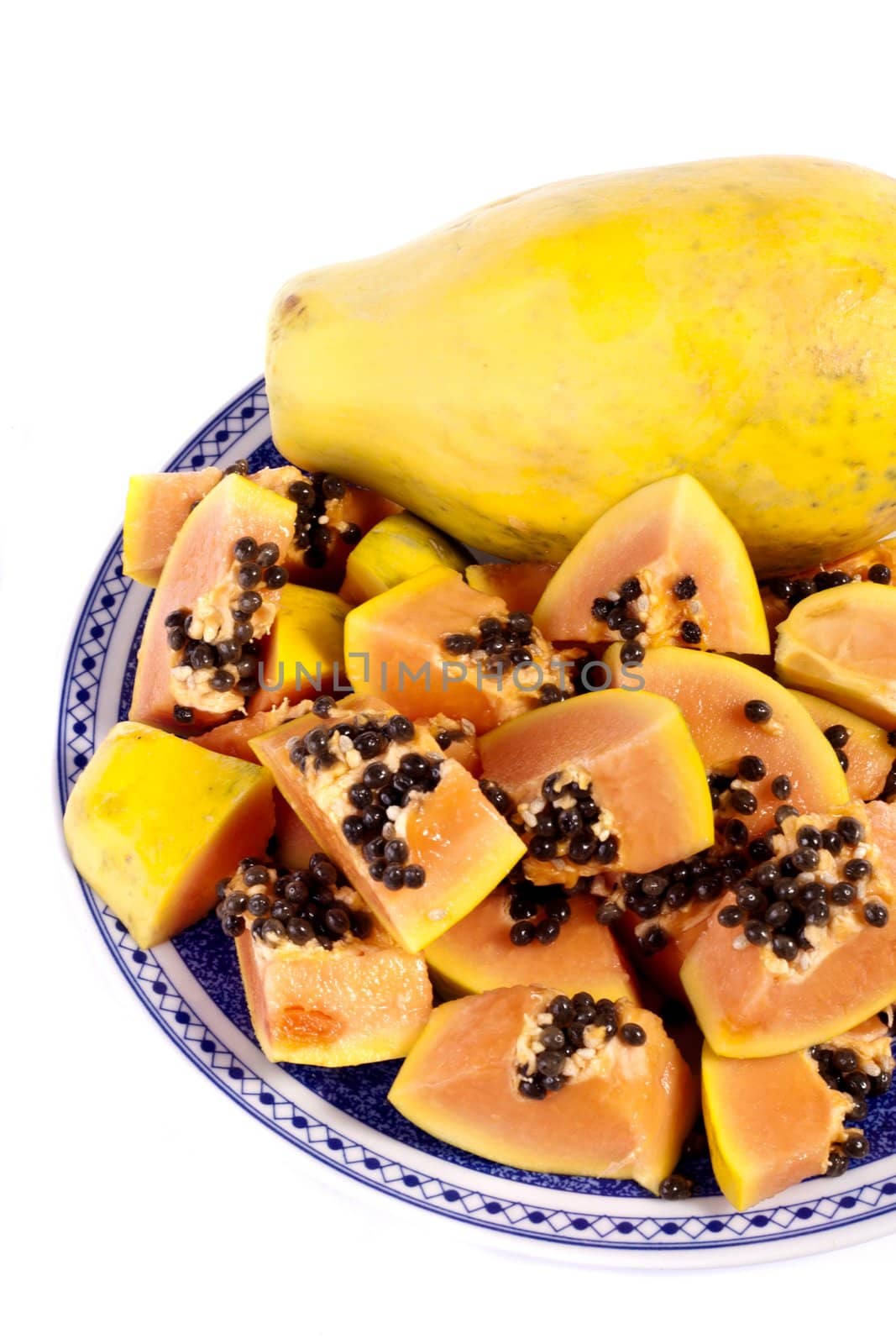 Close up view of papaya fruit sliced presented on a dish. 